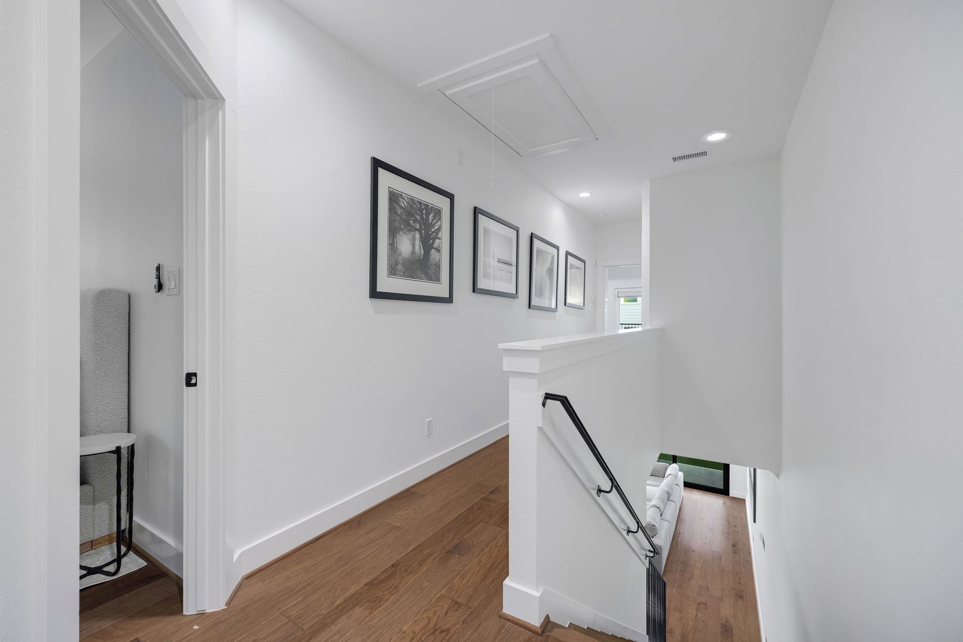 5537 Petty Street, Houston, TX 77007 Bright and inviting hallway with elegant wood flooring and recessed lighting leading to a cozy stairway.