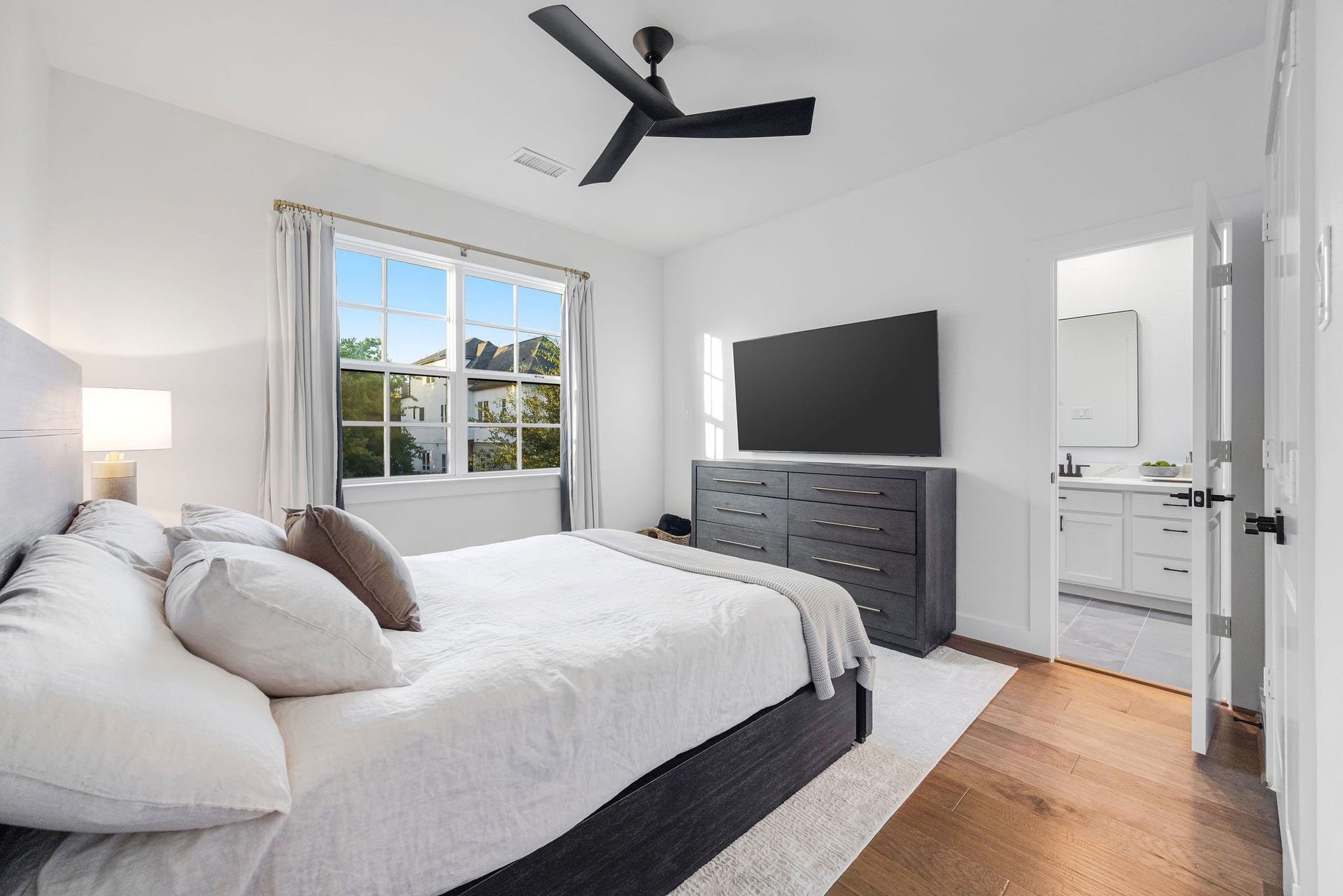 5537 Petty Street, Houston, TX 77007 Bright and airy bedroom with a large window, sleek ceiling fan, and an en-suite bathroom for added convenience.