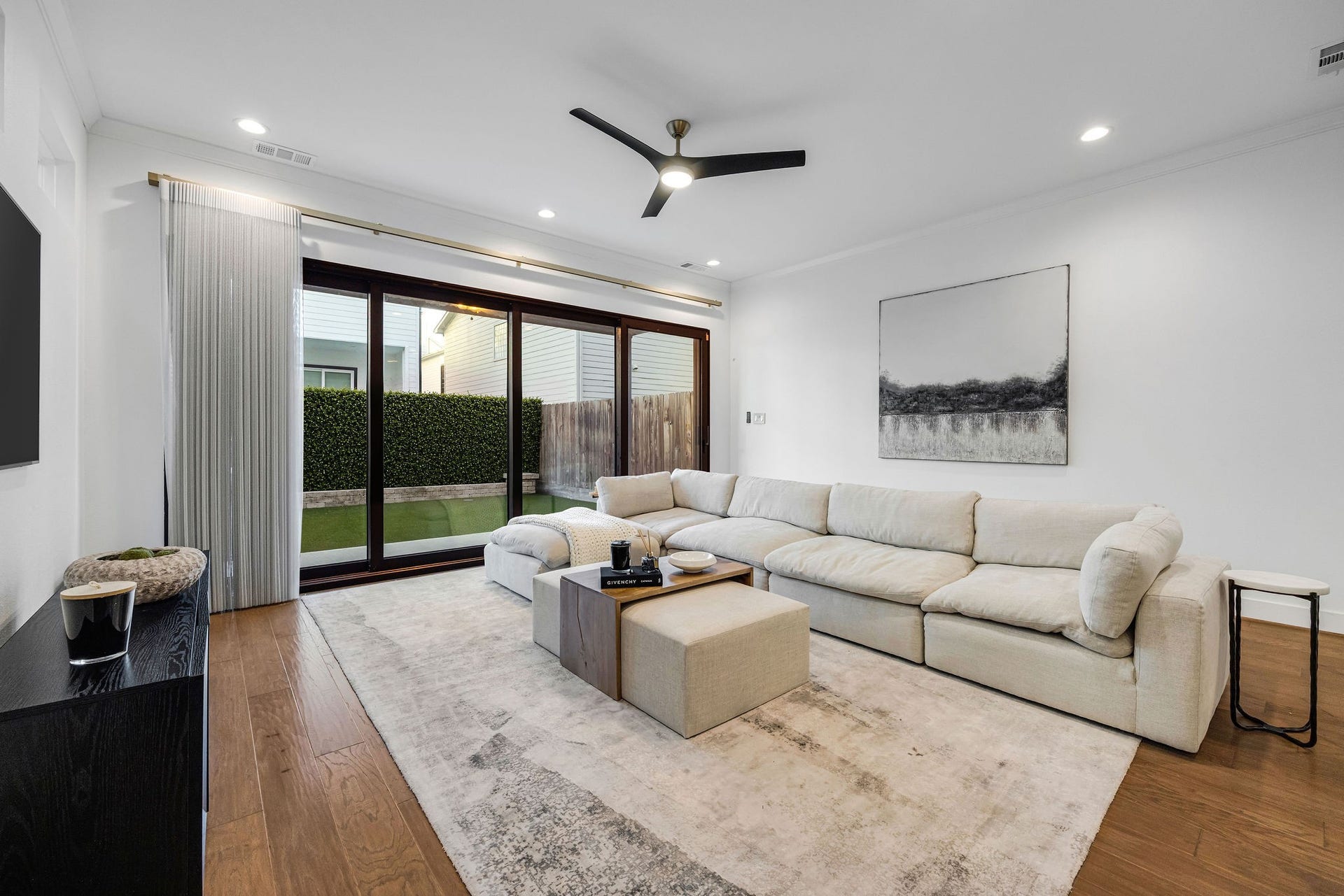 5537 Petty Street, Houston, TX 77007 Spacious living area with wood flooring, and large sliding glass doors offering abundant natural light and a seamless indoor-outdoor connection.
