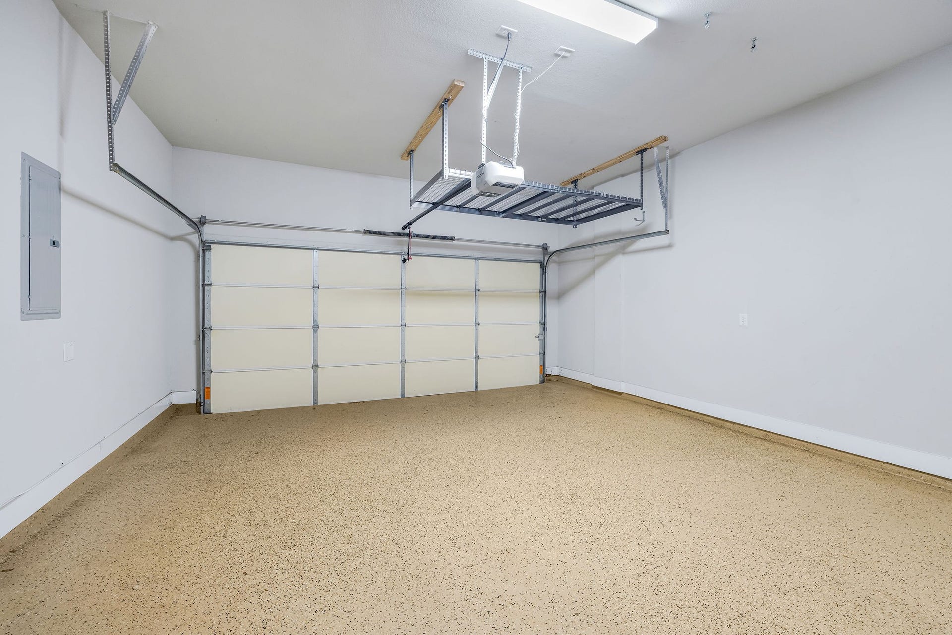 5537 Petty Street, Houston, TX 77007 Spacious garage with a polished, speckled floor, ample overhead storage, and a modern automatic door system.