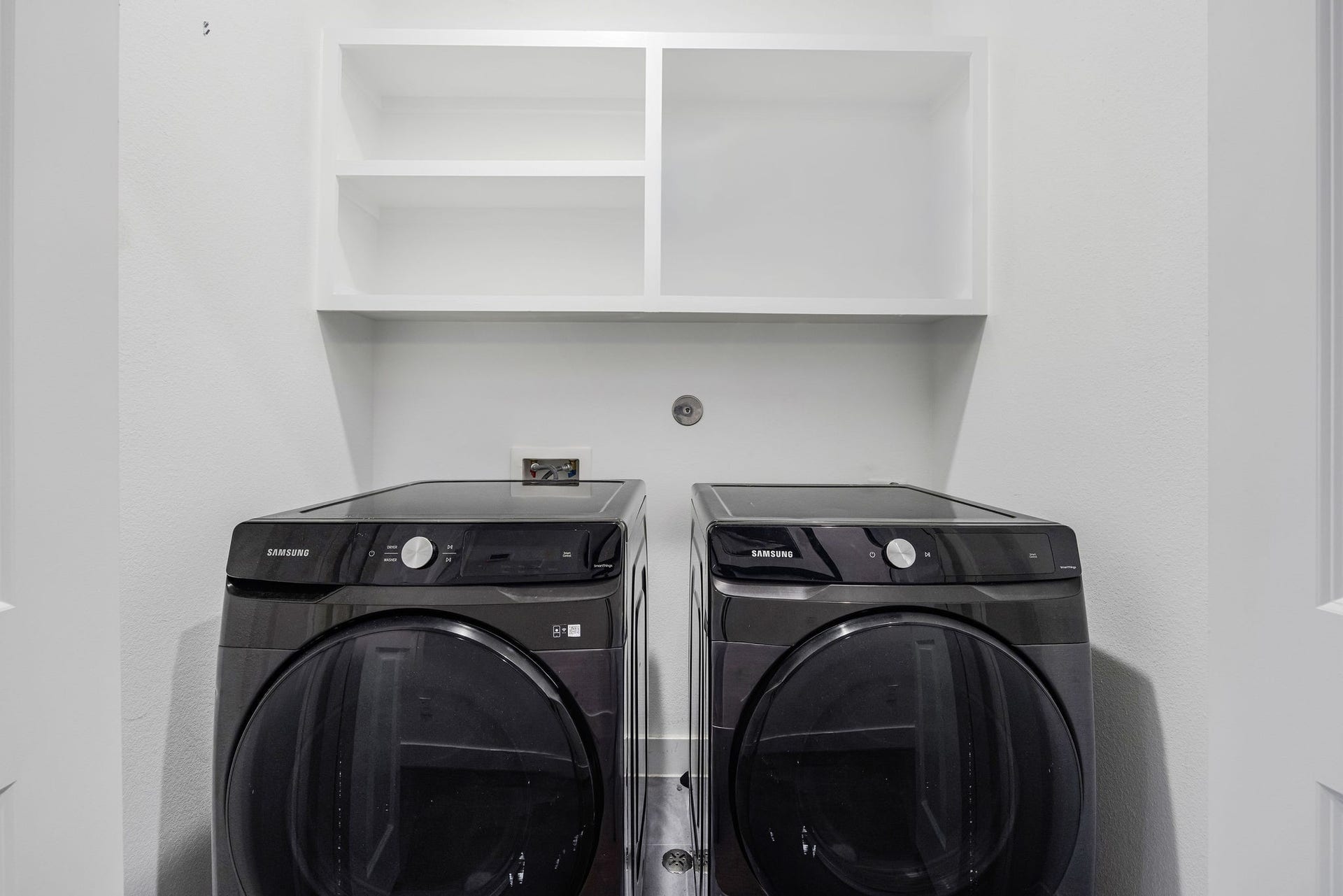 5537 Petty Street, Houston, TX 77007 Modern laundry area featuring sleek Samsung washer and dryer with convenient overhead shelving for storage.