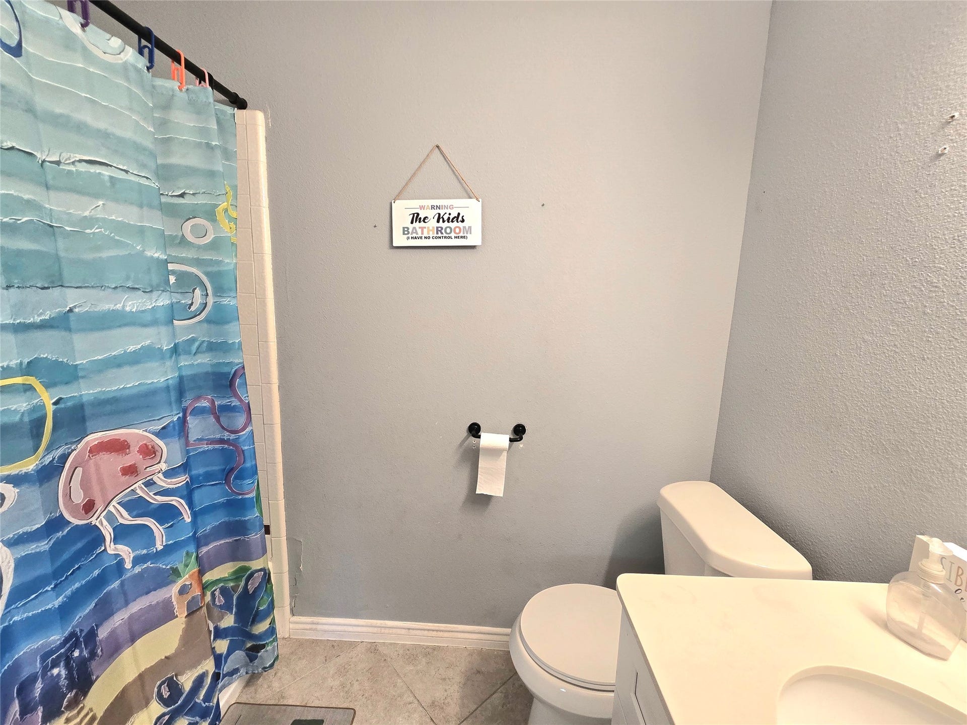 5205 Winding Brook Drive, Dickinson, TX 77539 Charming bathroom featuring a white vanity and soft gray walls for a bright and cheerful atmosphere.
