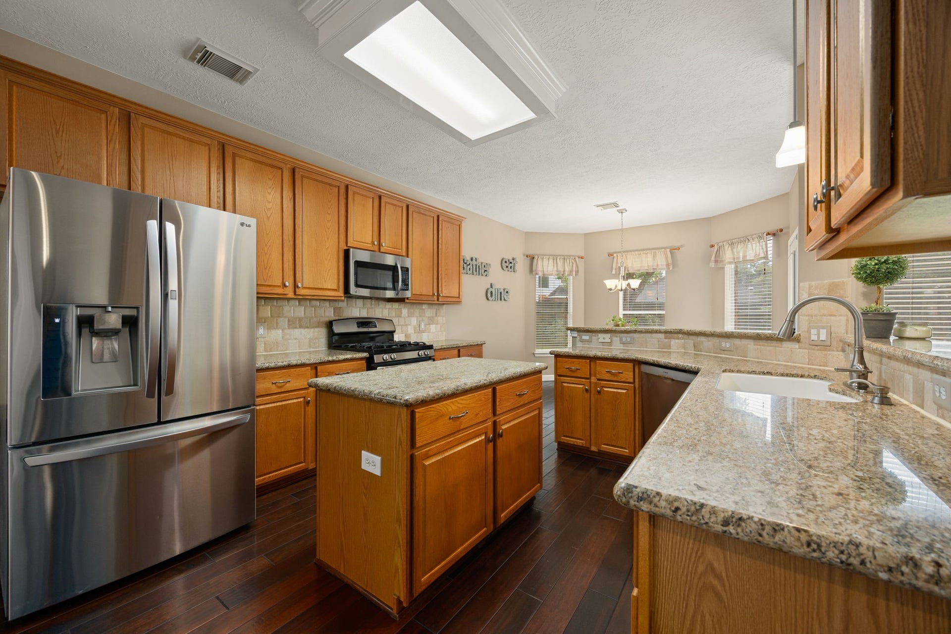 1427 Queens Bay Drive, Katy, TX 77494 The kitchen impresses with granite countertops, stainless steel appliances, and a center island offering extra workspace and storage.