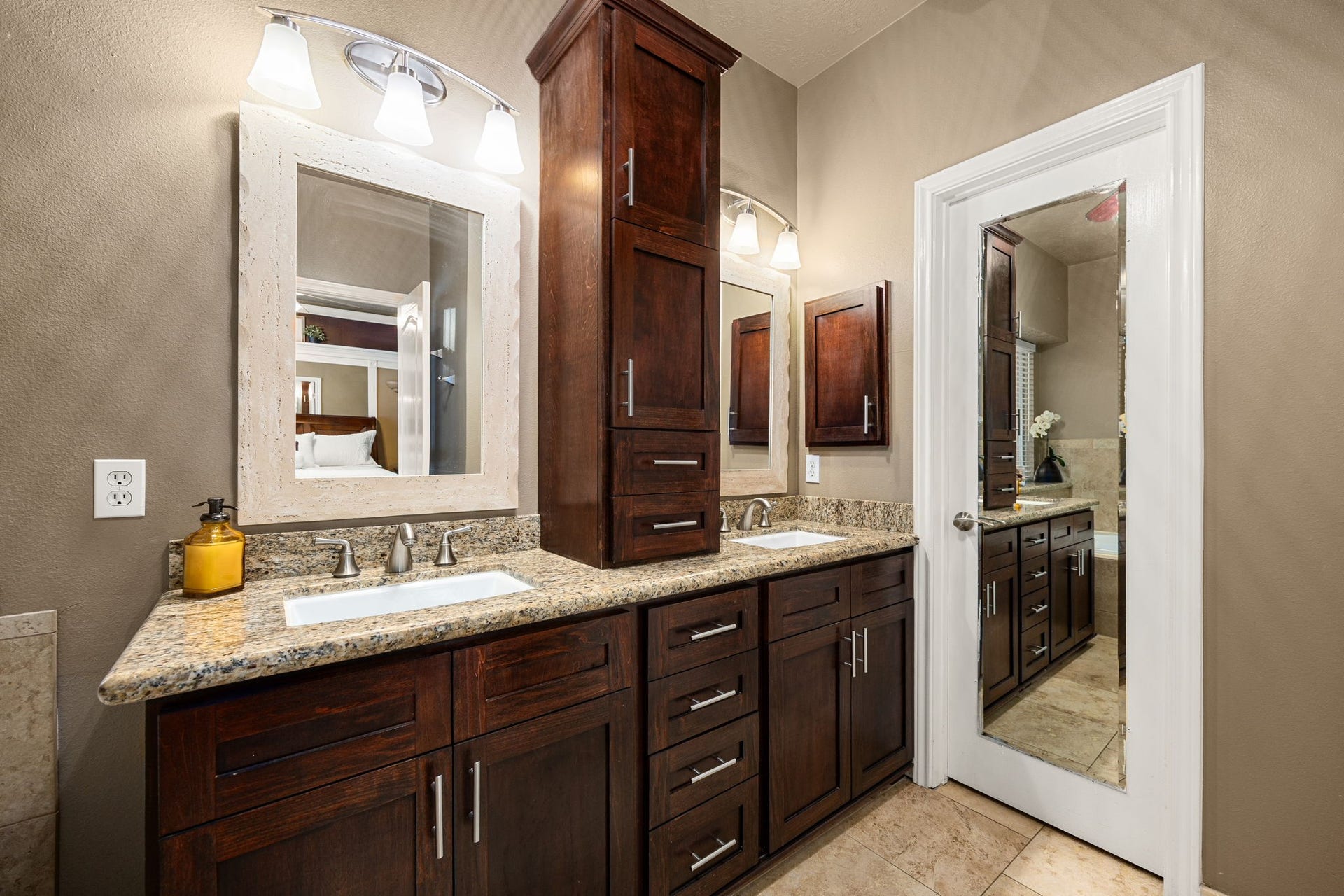 1427 Queens Bay Drive, Katy, TX 77494 The spa-like ensuite bathroom impresses with a dual-sink vanity, granite countertops, custom cabinetry, and framed mirrors.