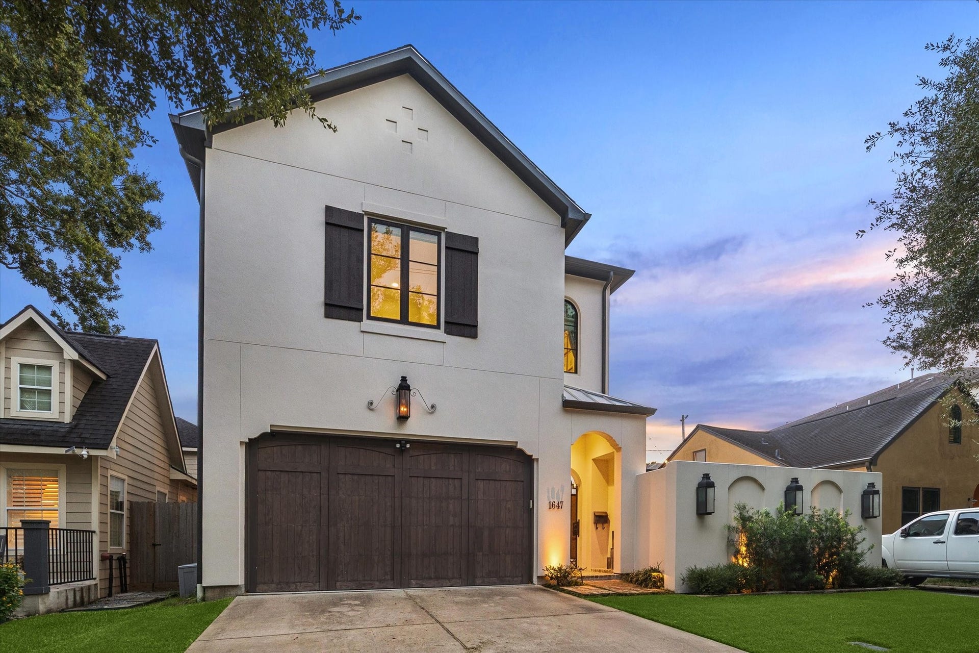 1647 Vassar Street, Houston, TX 77006 Evening exterior with warm, inviting entry lighting. Oversized custom cedar garage can accommodate larger vehicles.