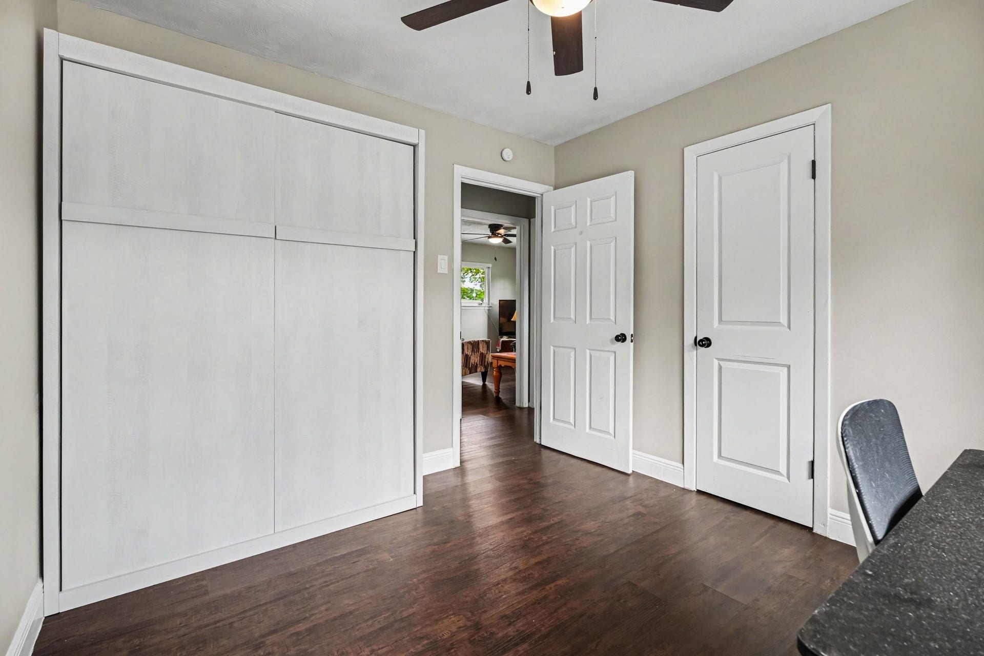 1317 N Natchez Drive, Texas City, TX 77591 Bedroom Two with elegant laminate floors, a ceiling fan, and ample closet space, offering a cozy and functional space. Murphy Bed folds up for additional space.