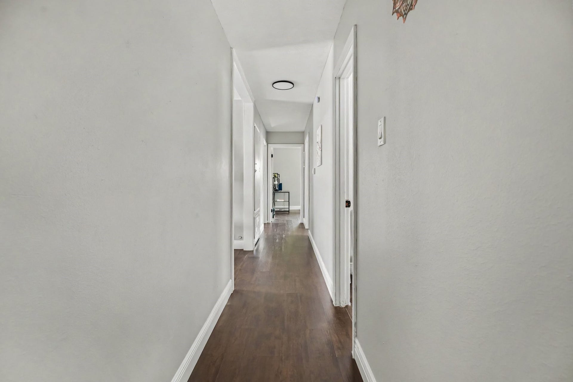 1317 N Natchez Drive, Texas City, TX 77591 Bright, inviting hallway connecting living areas featuring elegant floors and crisp white walls, leading to all bedroom and bathrooms.