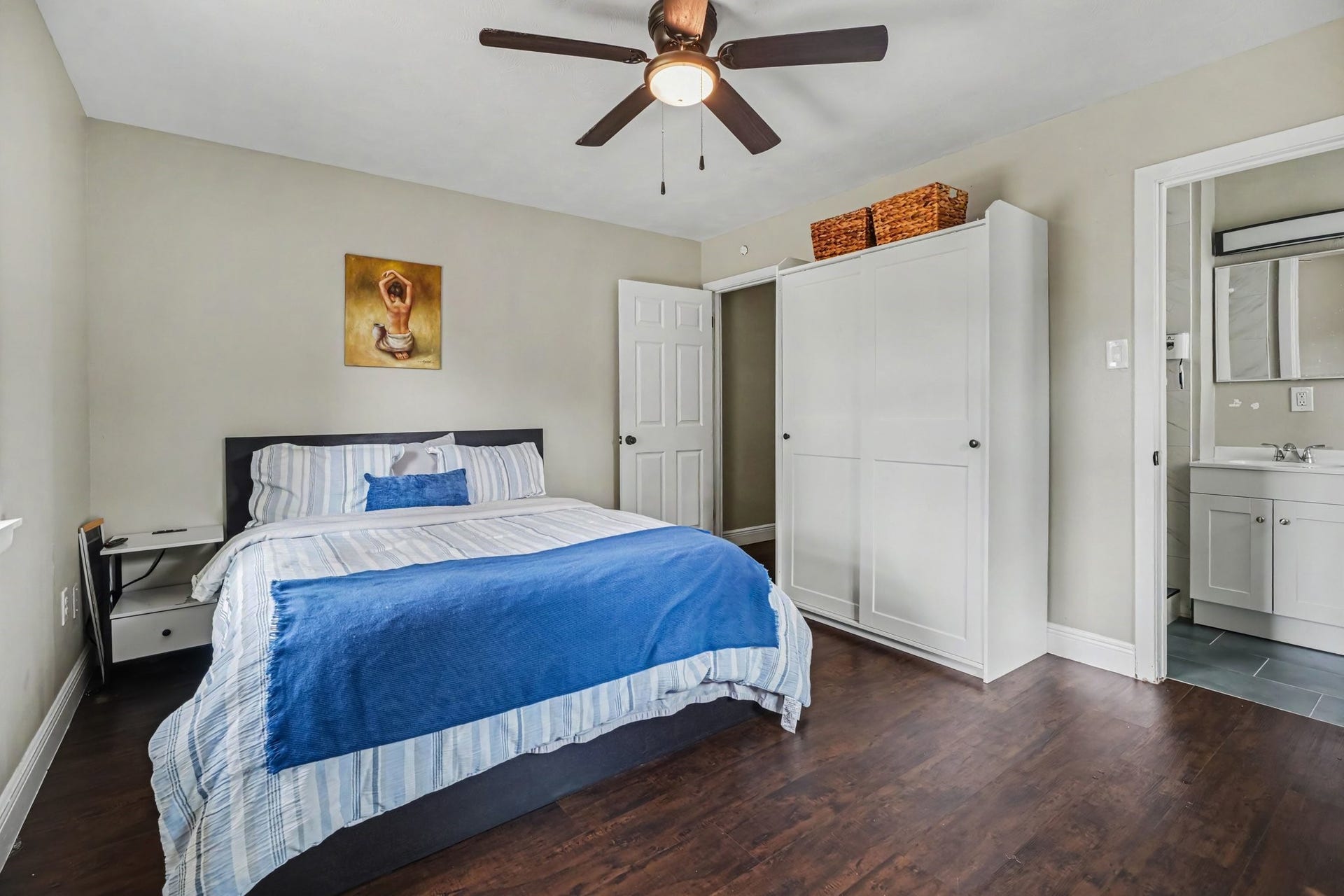1317 N Natchez Drive, Texas City, TX 77591 Primary bedroom featuring hardwood floors, ample natural light from two windows, and a ceiling fan for comfort.