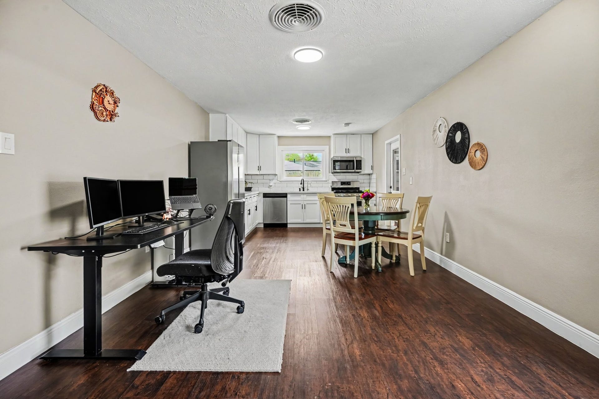 1317 N Natchez Drive, Texas City, TX 77591 Bright and inviting kitchen and dining area featuring sleek laminate floors, modern appliances, and a cozy dining nook. An adjacent workspace offers functionality and style.