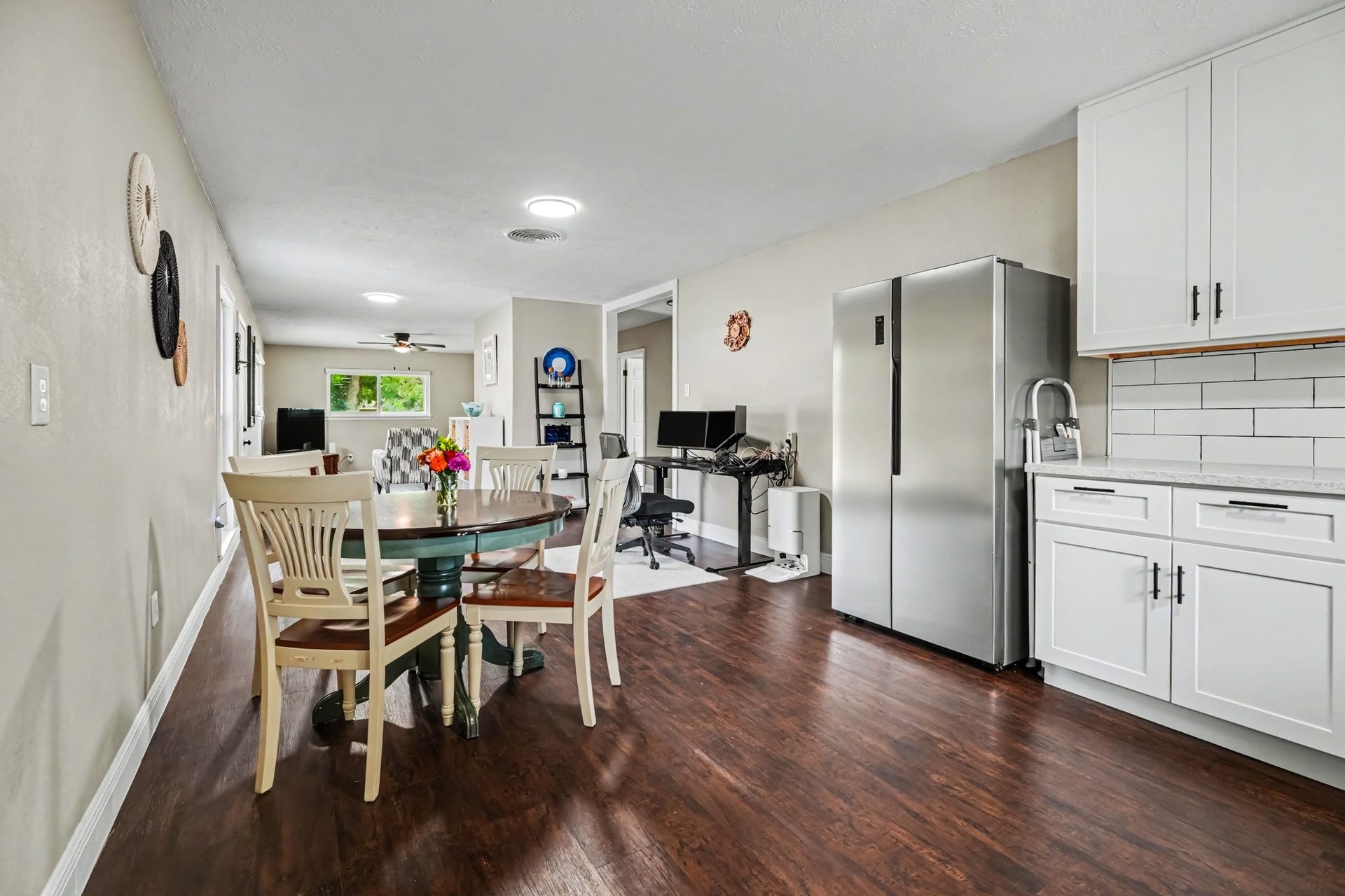 1317 N Natchez Drive, Texas City, TX 77591 Spacious open-plan dining and kitchen area featuring modern stainless steel appliances, sleek white cabinetry, and laminate flooring, creating an inviting and functional living space.