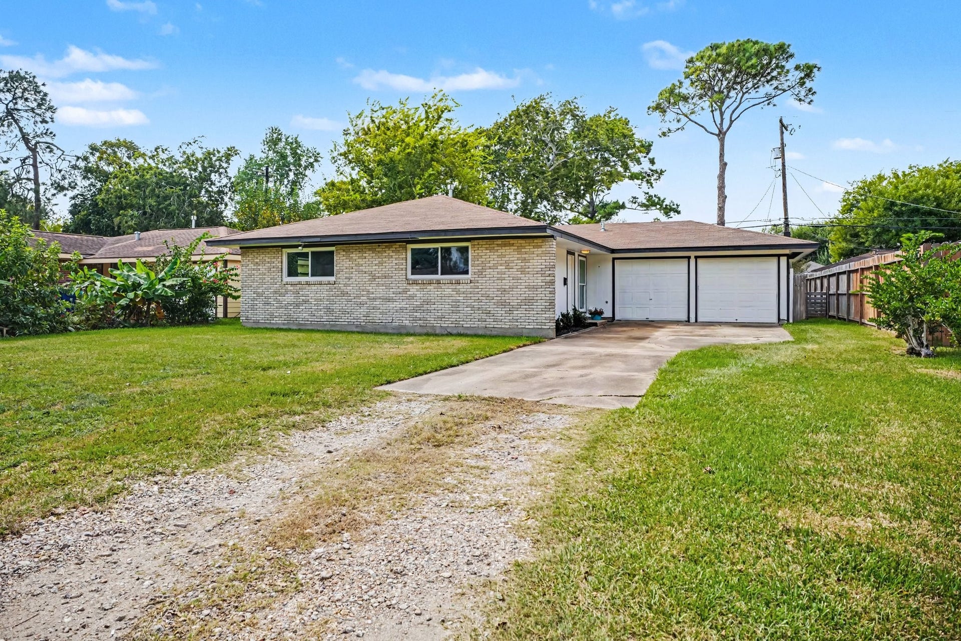 1317 N Natchez Drive, Texas City, TX 77591 Charming single-story home with a spacious front yard, two-car drive way and garage, and brick exterior, nestled in a serene neighborhood.