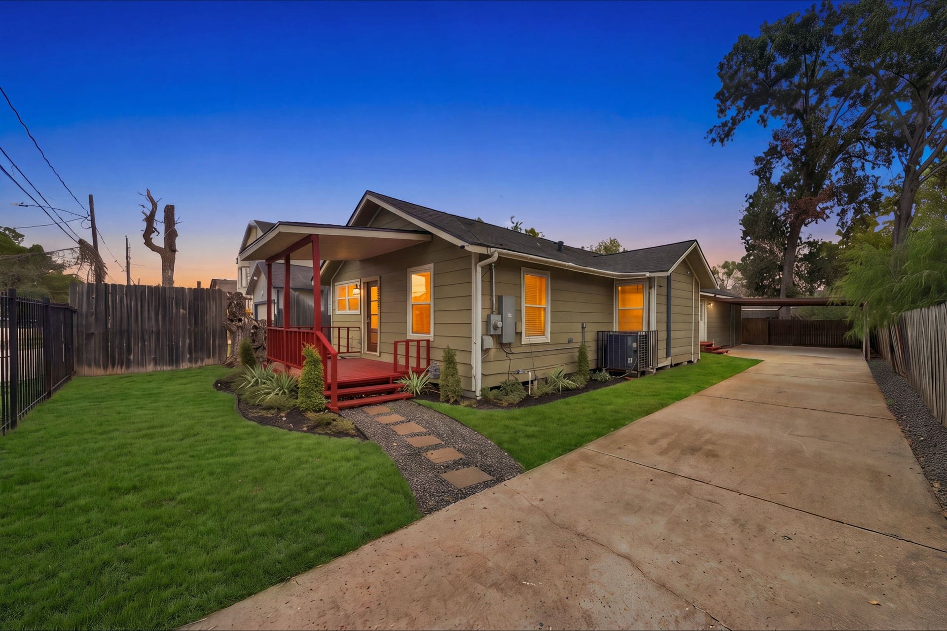 4637 Larkspur Street, Houston, TX 77051 Charming single-story home with a welcoming front porch, vibrant landscaping, and a spacious driveway leading to a carport, set against a serene evening sky.