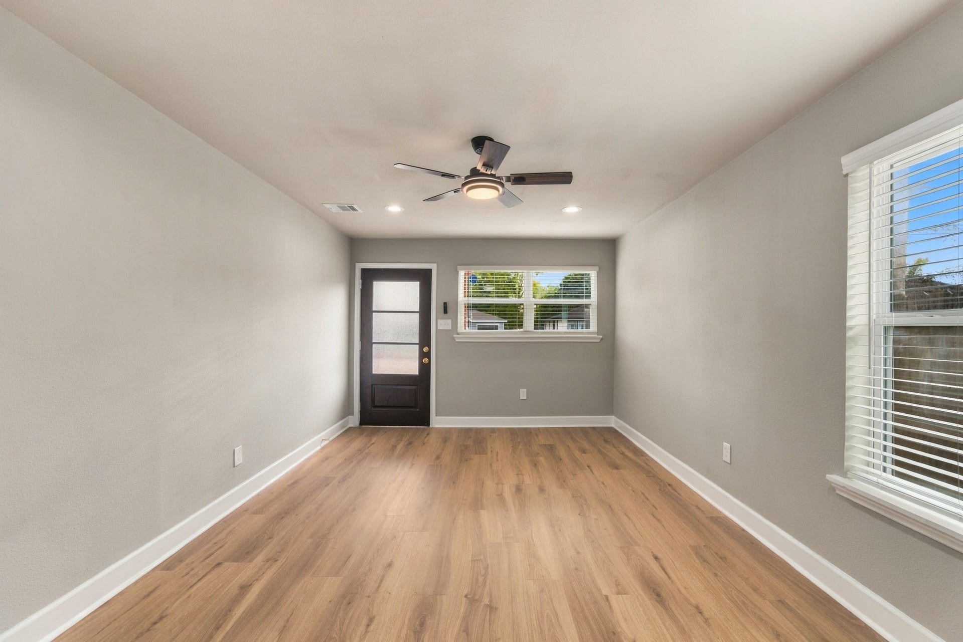 4637 Larkspur Street, Houston, TX 77051 Bright and inviting room with wood flooring, complemented by a modern ceiling fan and ample natural light from multiple windows.
