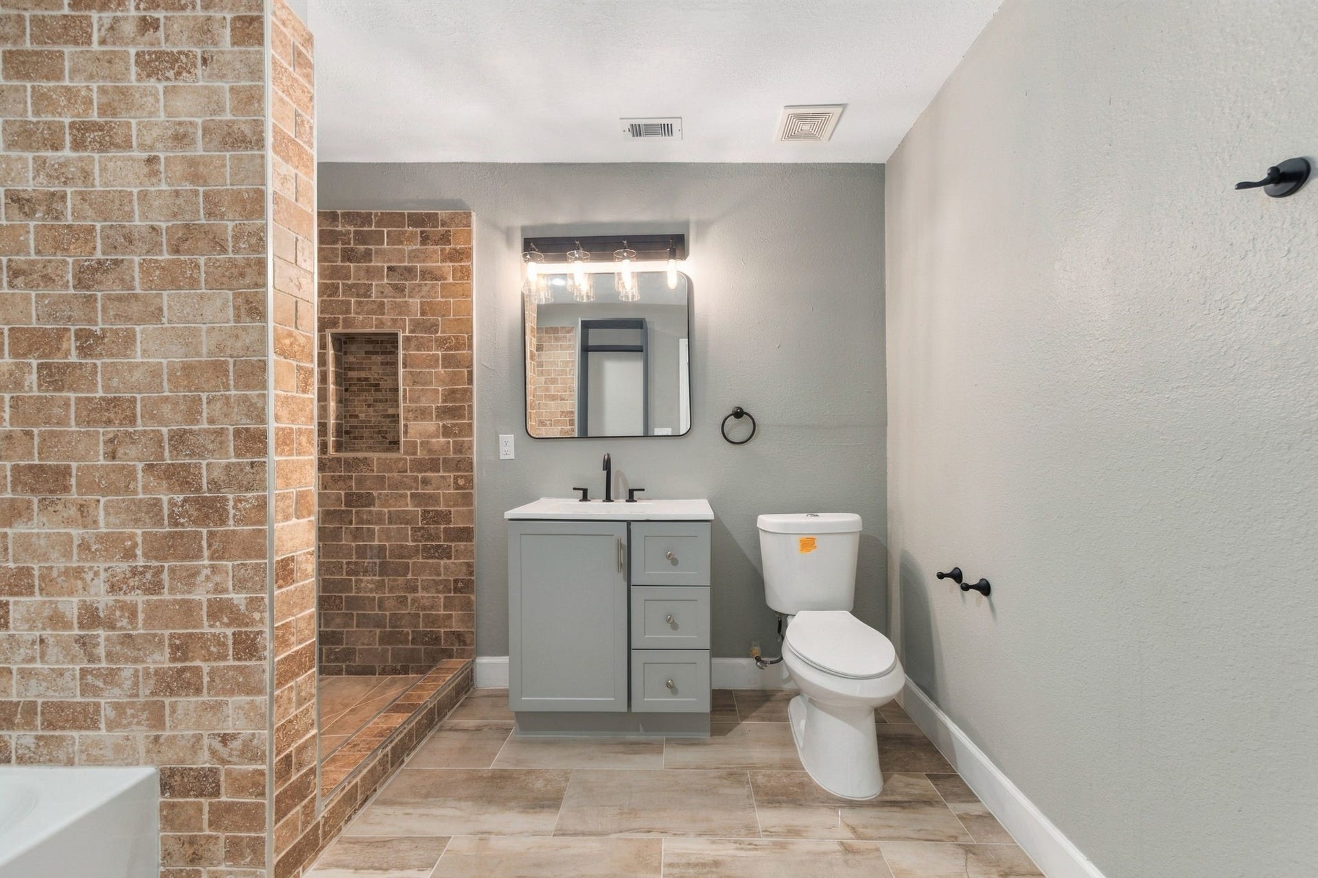 4637 Larkspur Street, Houston, TX 77051 Stylish bathroom with a modern vanity, sleek fixtures, and a spacious walk-in shower featuring elegant brick-style tilework.