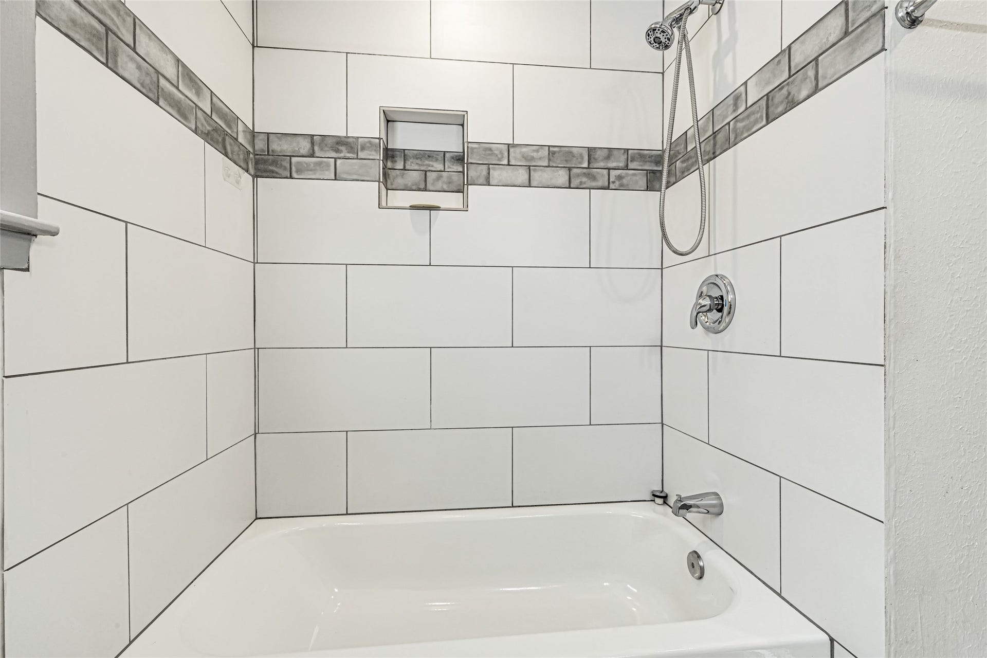209 W 6th Street, Deer Park, TX 77536 Sleek and modern hall bath featuring a stylish tub and shower combo with elegant tile accents.