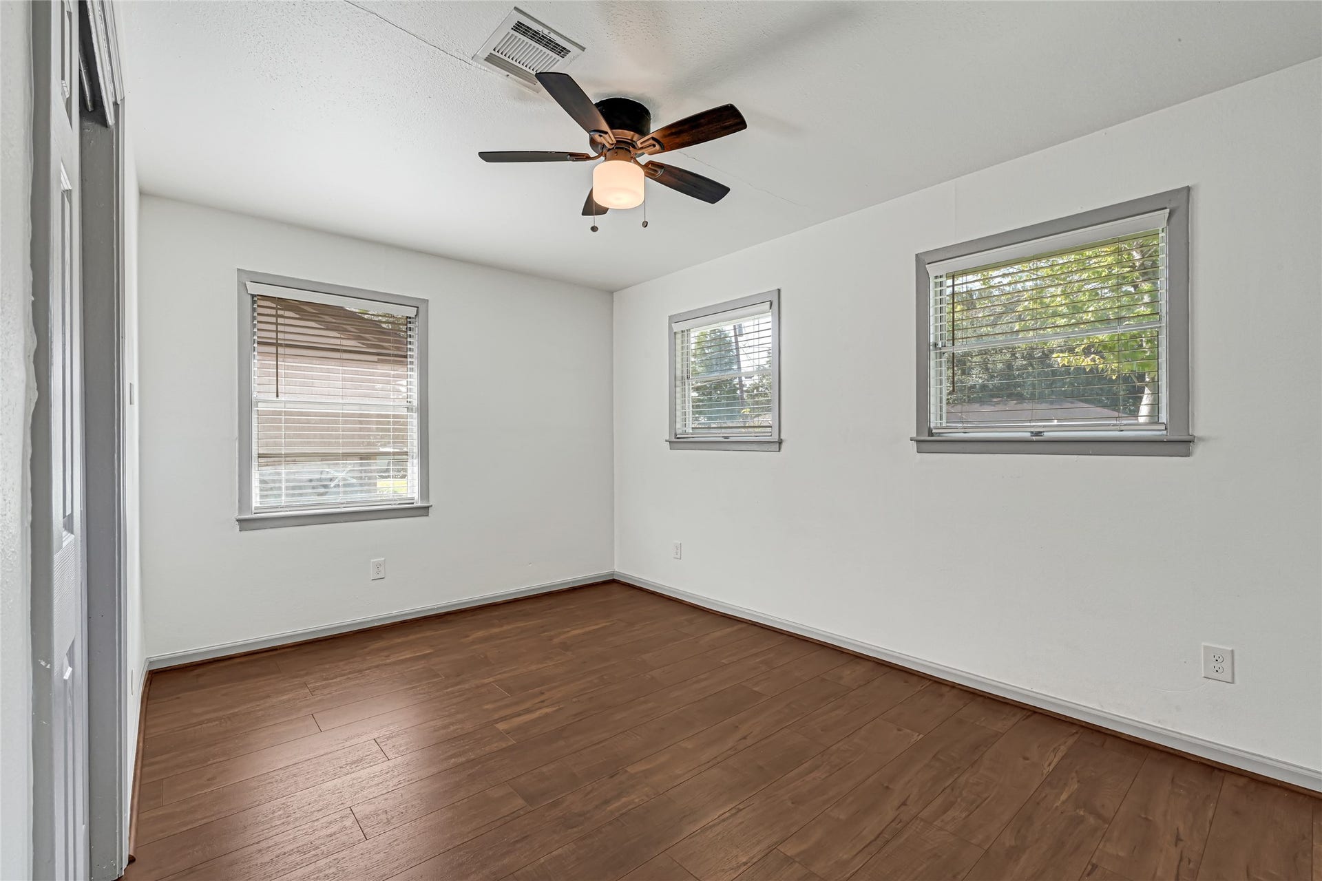 209 W 6th Street, Deer Park, TX 77536 Sunlit Bedroom 3 offers an inviting atmosphere with abundant natural light flooding through multiple windows.