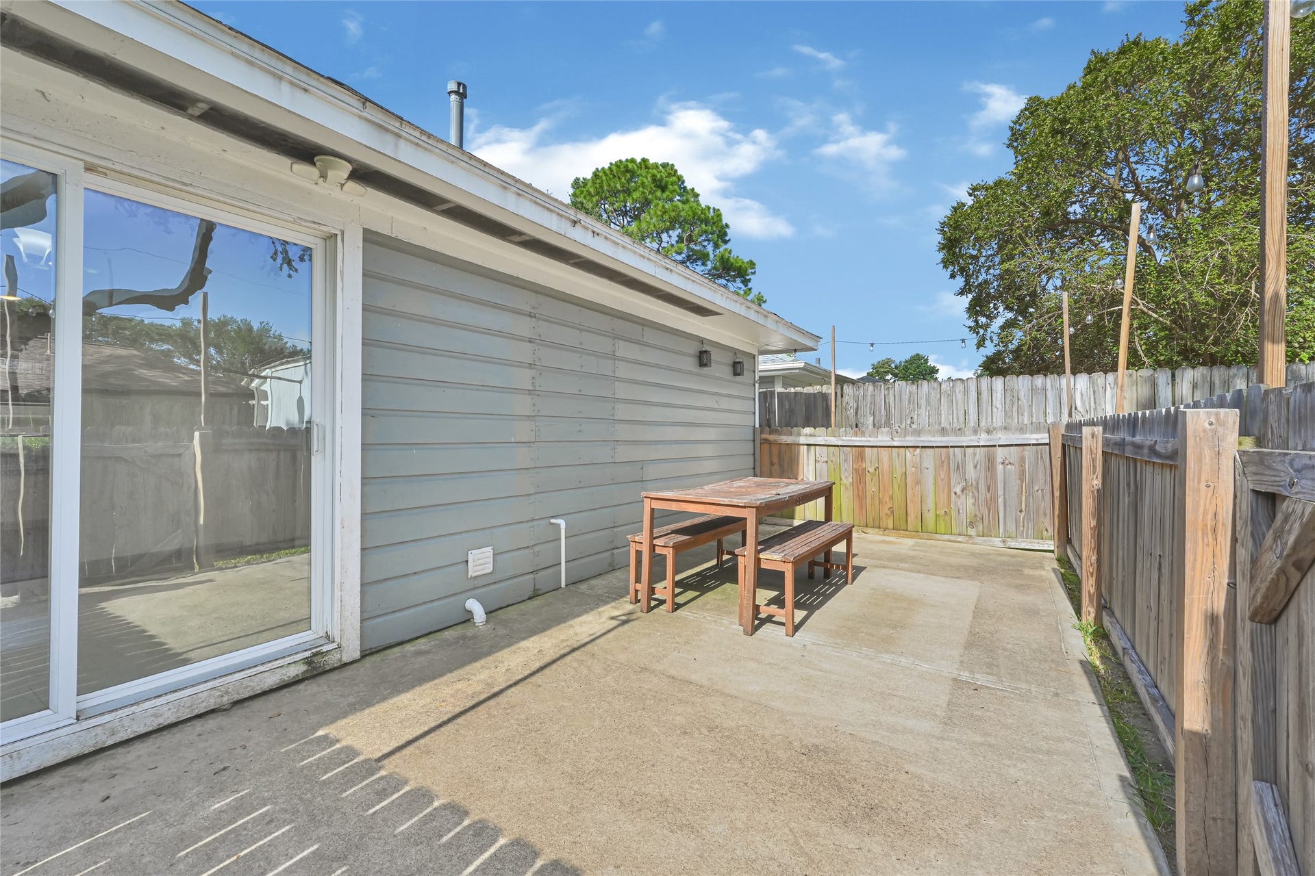 209 W 6th Street, Deer Park, TX 77536 Spacious back patio offers versatile options for dining, grilling, or creating a cozy dog run, perfect for outdoor living.