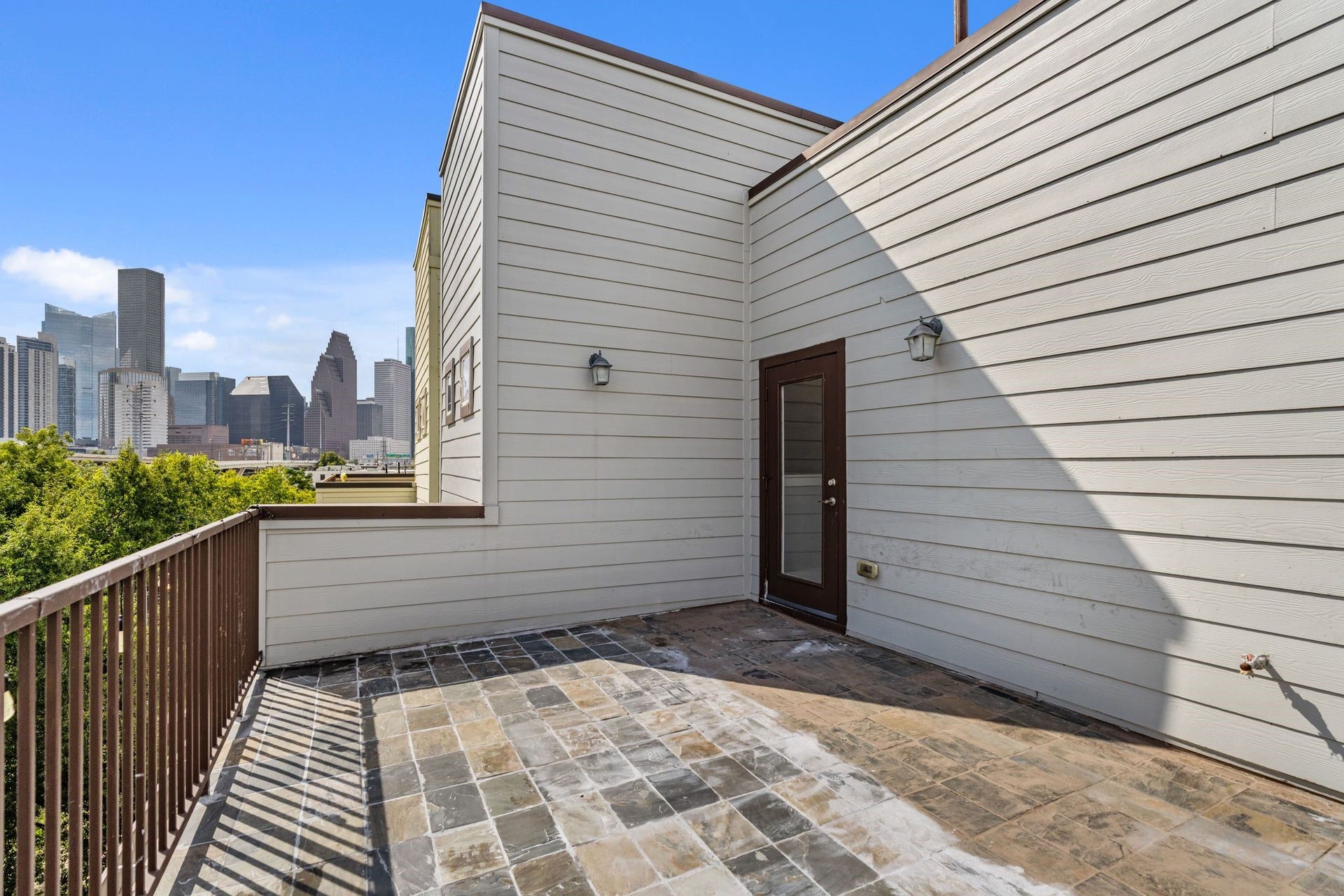 1005 Bingham Street, #5, Houston, TX 77007 Fourth-floor terrace with views of the Downtown Houston skyline, offering an outdoor space for relaxing or entertaining.