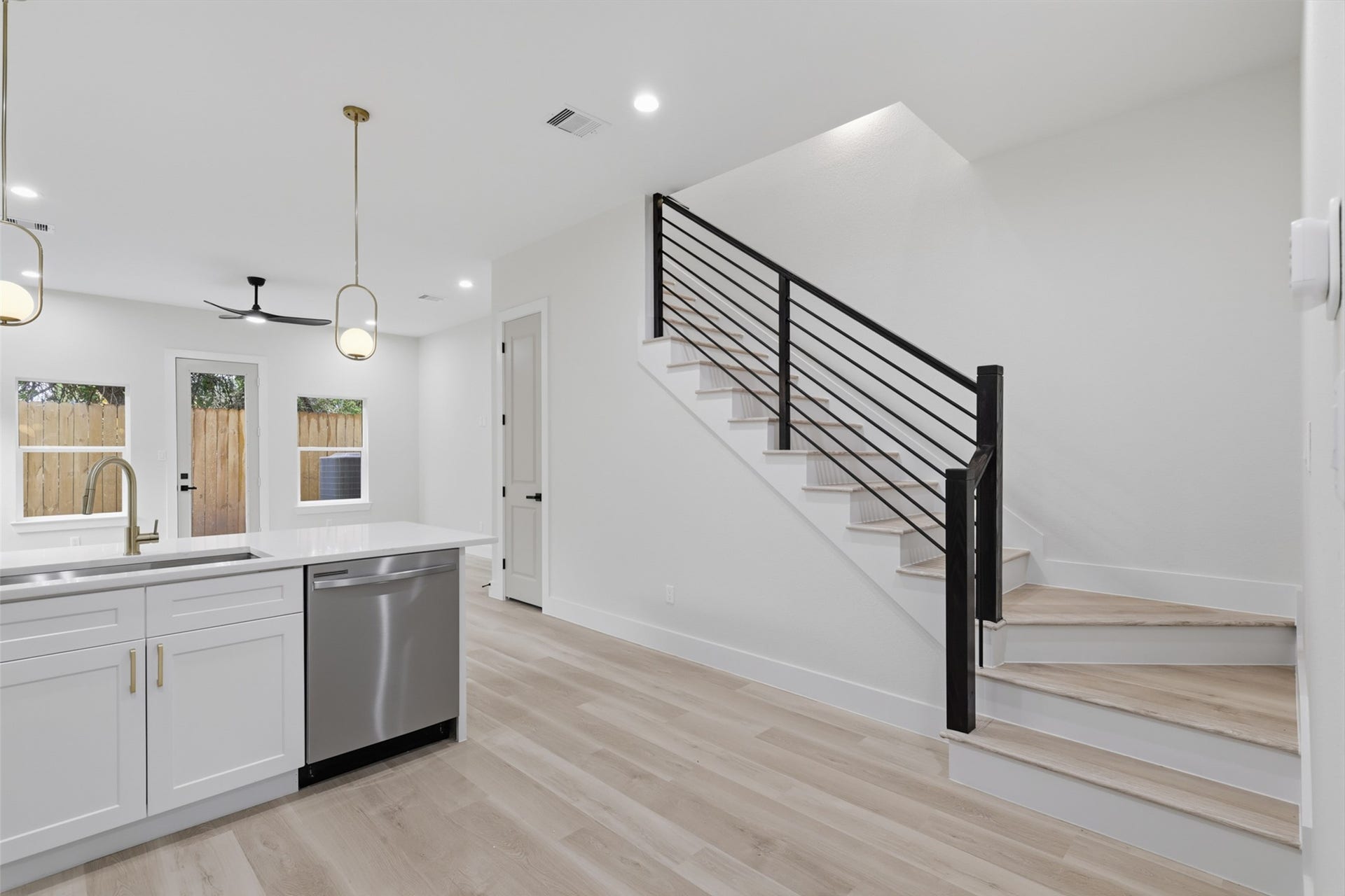 3205 Berry Street, #A/B, Houston, TX 77004 Bright and modern upstairs landing with sleek railings, recessed lighting, and access to a sunlit room, creating a welcoming and open atmosphere.
