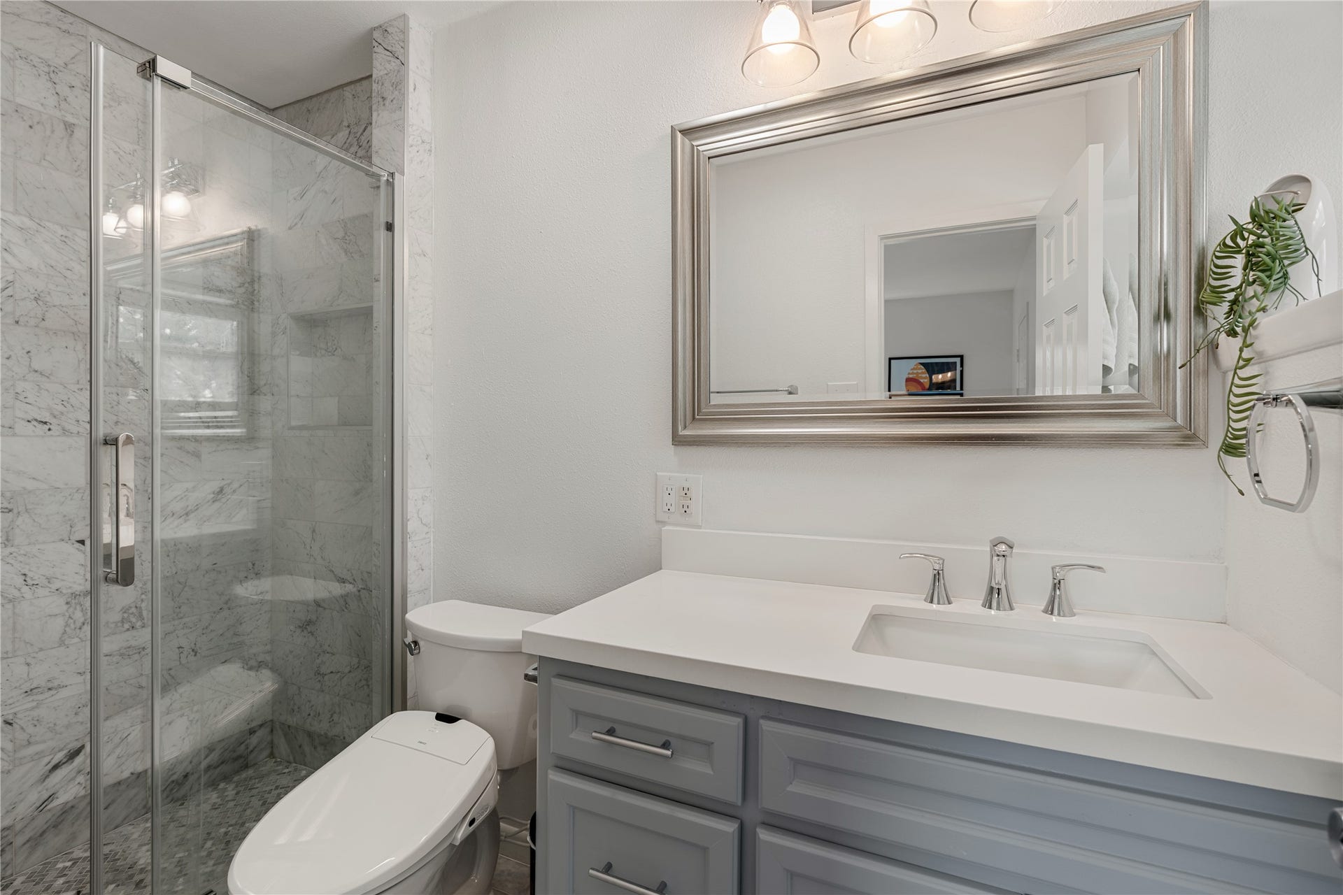 2302 Willowby Drive, Houston, TX 77008 Renovated in 2025, the elegant primary bathroom features a stylish marble-tiled shower, modern fixtures, and a spacious vanity.