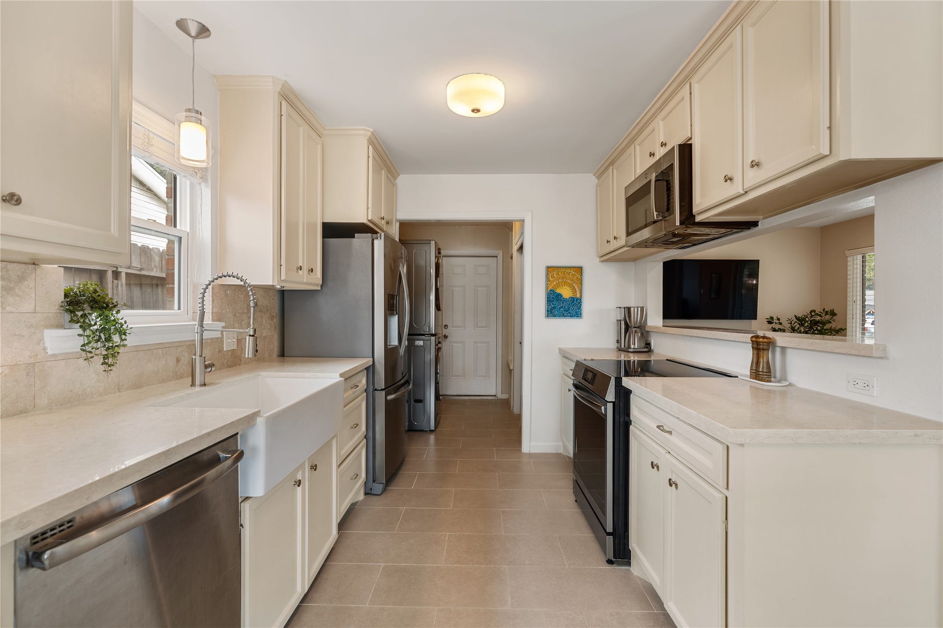2302 Willowby Drive, Houston, TX 77008 Bright and inviting kitchen featuring modern stainless steel appliances, sleek countertops, and window overlooking porcelain farmhouse sink.