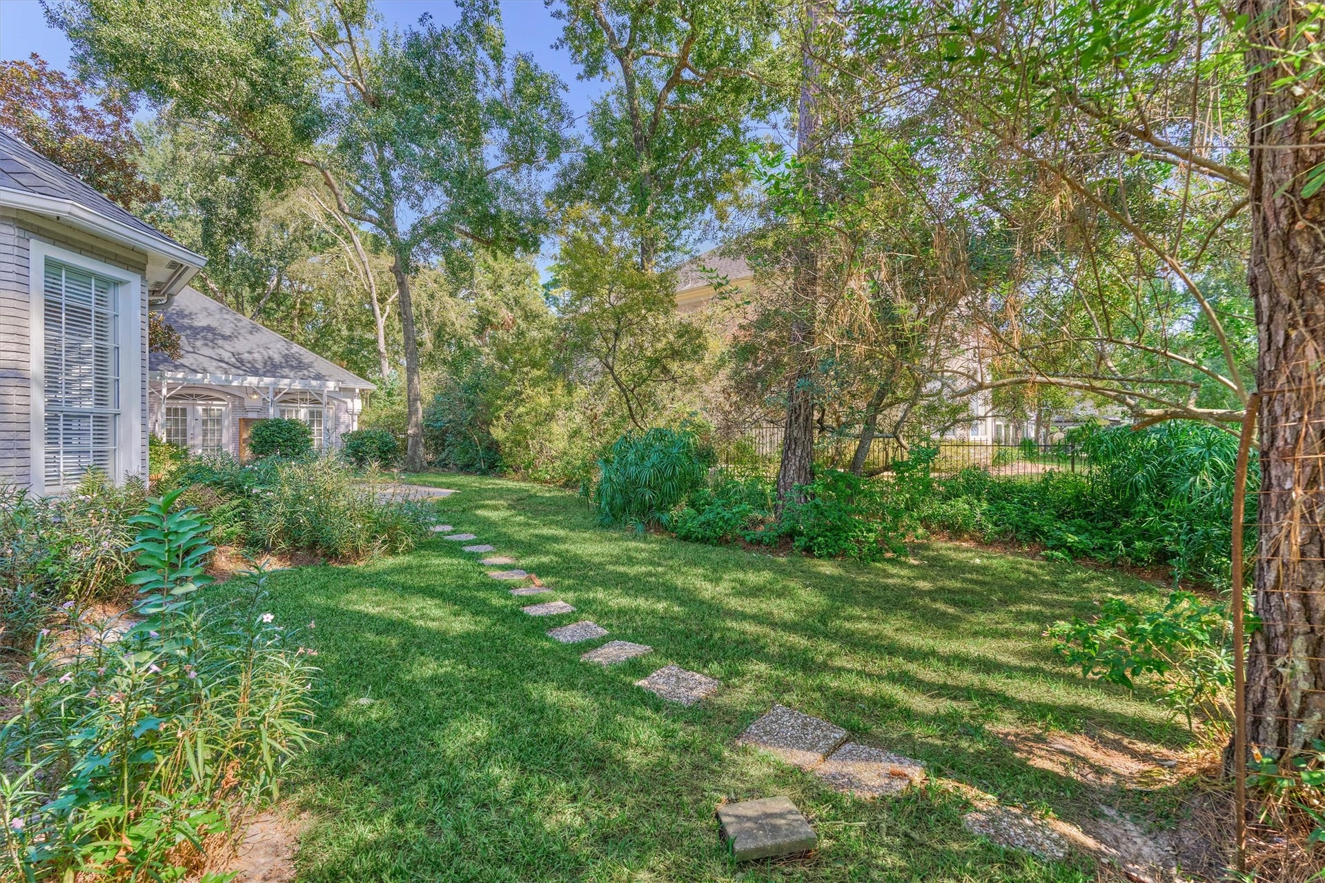 26 S Brokenfern Drive, The Woodlands, TX 77380 Picture a pool, a play area, or a garden in this spacious backyard, which has plenty of room to build the outdoor space you want. Tall trees give it shade and privacy, and a stepping-stone path winds from the patio across the lawn. The inground spa and covered patio are already in place, so you can start entertaining right away.