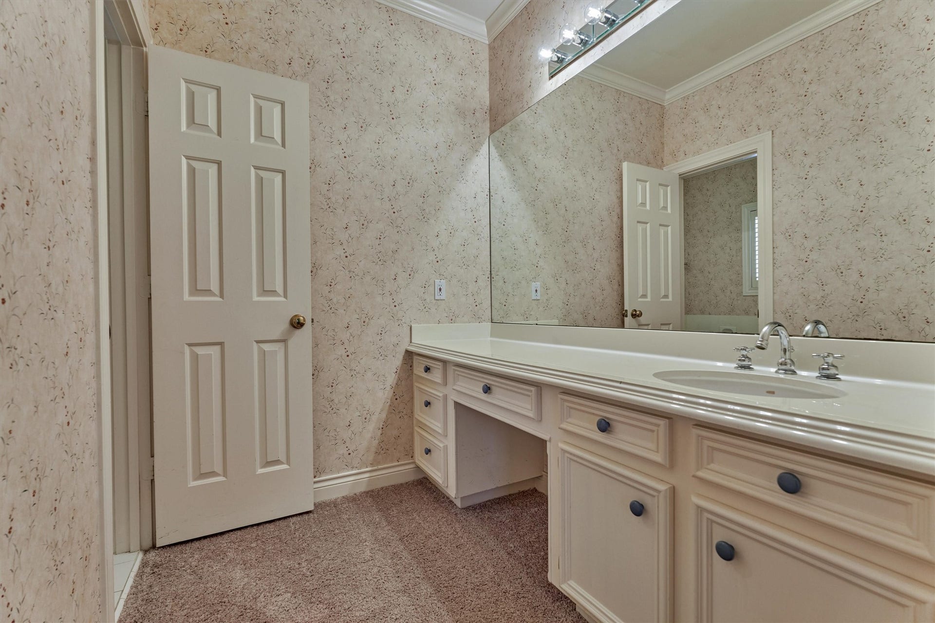 26 S Brokenfern Drive, The Woodlands, TX 77380 Mornings run smoothly in this shared bath setup, where each bedroom has its own sink and counter. This side offers a long vanity with plenty of drawers and cabinets, plus a seated makeup or grooming area. A wide mirror and bright lighting make getting ready easy, and the separate bath area keeps privacy where it counts.
