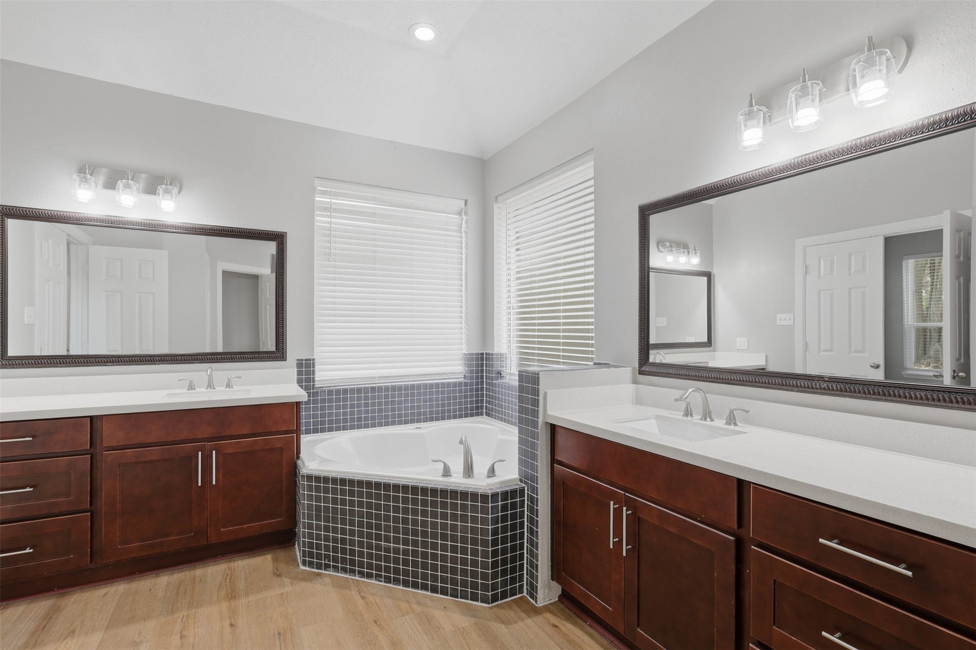 Your sumptuous primary suite bathroom retreat is designed for everyday luxury, featuring upgraded custom his-and-her private vanities with gorgeous sparkling quartz countertops, deep undermount sinks, elegant, framed mirrors, and abundant cabinetry for exceptional storage. A spacious linen closet provides even more room for towels and essentials, creating the perfect blend of beauty, comfort, and functionality.