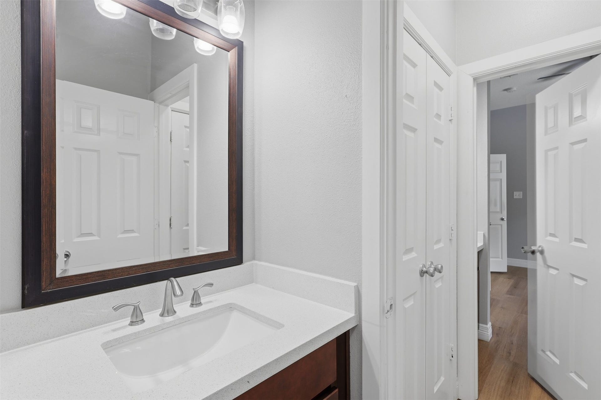 The beautifully updated guest bathroom showcases gorgeous quartz countertops, deep undermount sinks, custom designer faucets, and abundant cabinetry for everyday convenience. A spacious linen closet provides additional storage, while the private bath and shower area offers added comfort and privacy. Quality craftsmanship and timeless finishes throughout reflect the exceptional design of this custom home.