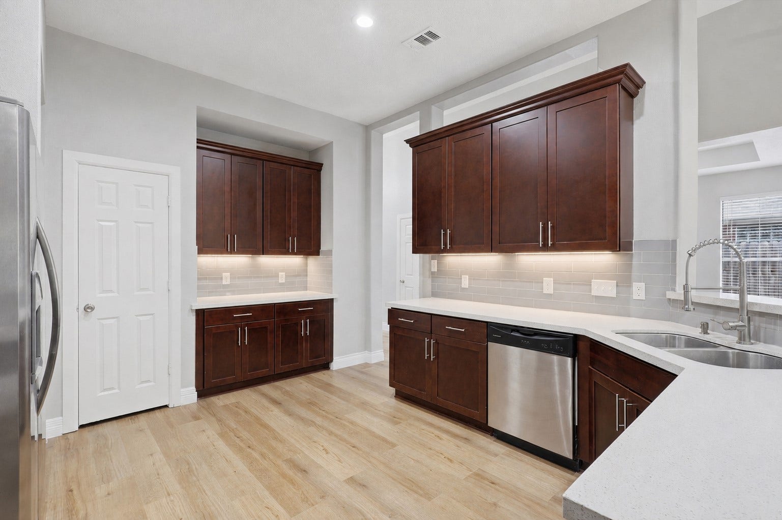 Your gourmet kitchen is designed to impress, featuring a huge wraparound breakfast bar that's perfect for entertaining family and friends or enjoying a quick breakfast, casual lunch, or late-night snack. Gorgeous sparkling quartz countertops shine like diamonds, beautifully complemented by a chic designer tile backsplash, tall custom cabinetry with under-cabinet lighting, and abundant workspace. This stunning kitchen combines timeless elegance with exceptional functionality!