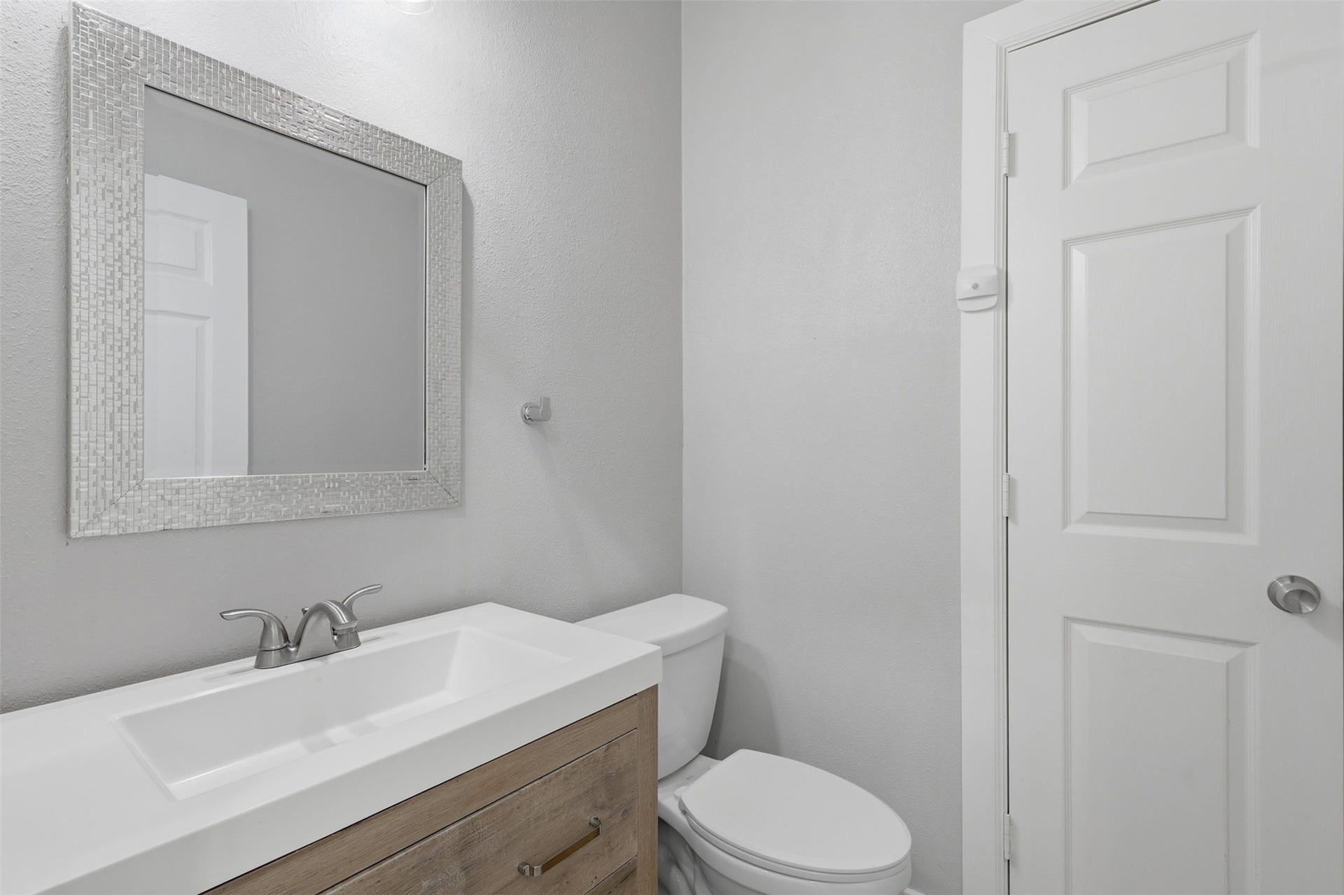 Welcome your family and guests with this beautifully updated powder room! Featuring a stylish vanity with a deep undermount sink, gorgeous quartz countertops, and designer finishes, this space makes a lasting impression. A convenient linen closet provides plenty of storage for towels and everyday essentials, combining beauty with functionality.