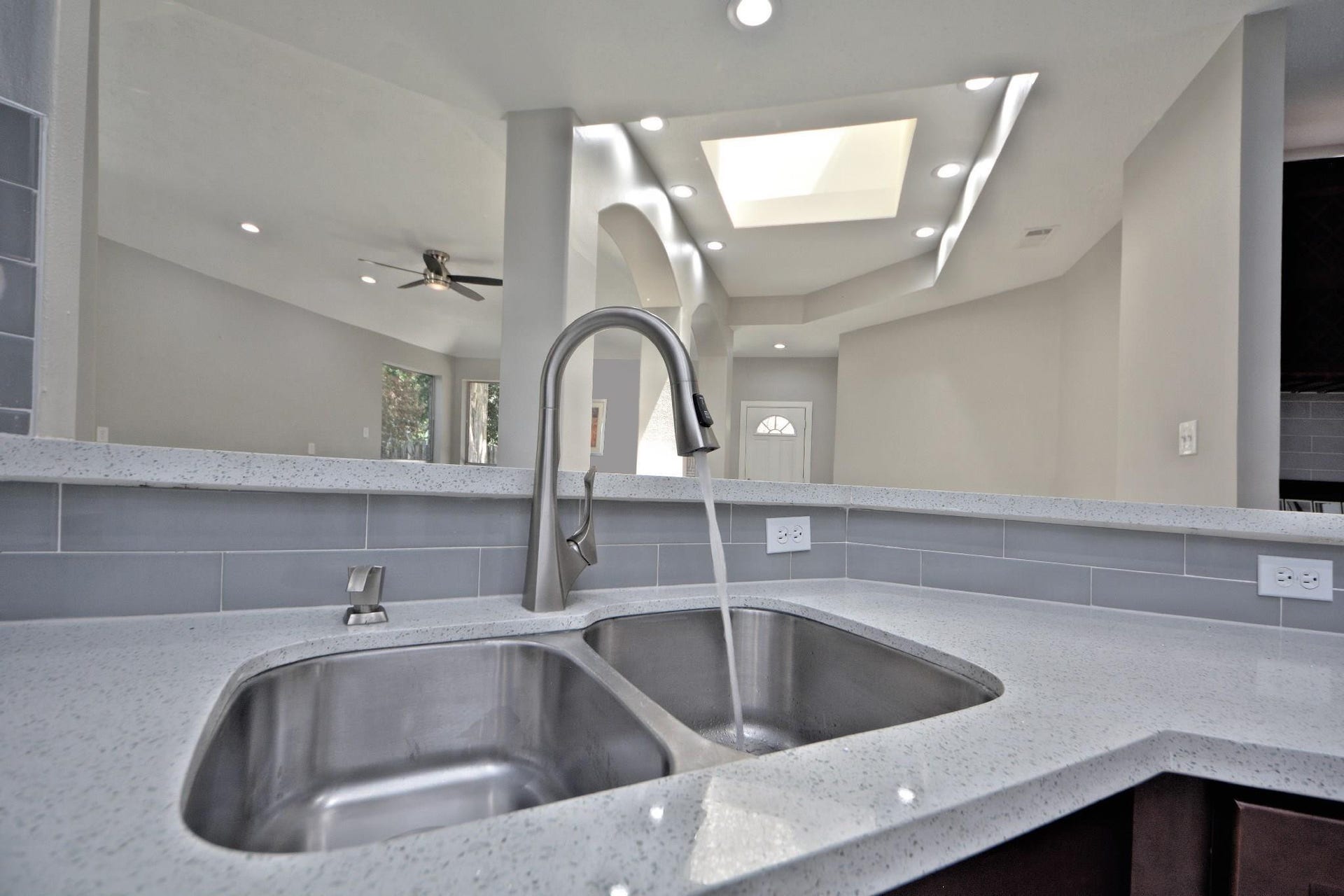 The gourmet kitchen is beautifully appointed with a deep undermount stainless steel sink, a custom Swan pull-down kitchen faucet, a convenient built-in soap dispenser, and thoughtful designer finishes throughout. Enjoy the timeless view from your kitchen while preparing meals or entertaining, making this space as functional as it is beautiful.
