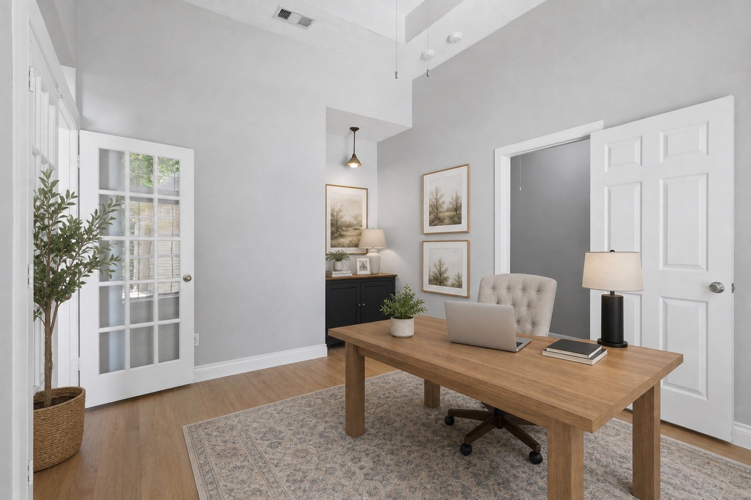 Tall, stunning French glass-paneled doors welcome you into the impressive home office, featuring dramatic coffered ceilings, abundant natural light, and plenty of space to work from home in style and comfort. Photo is Virtually Staged.