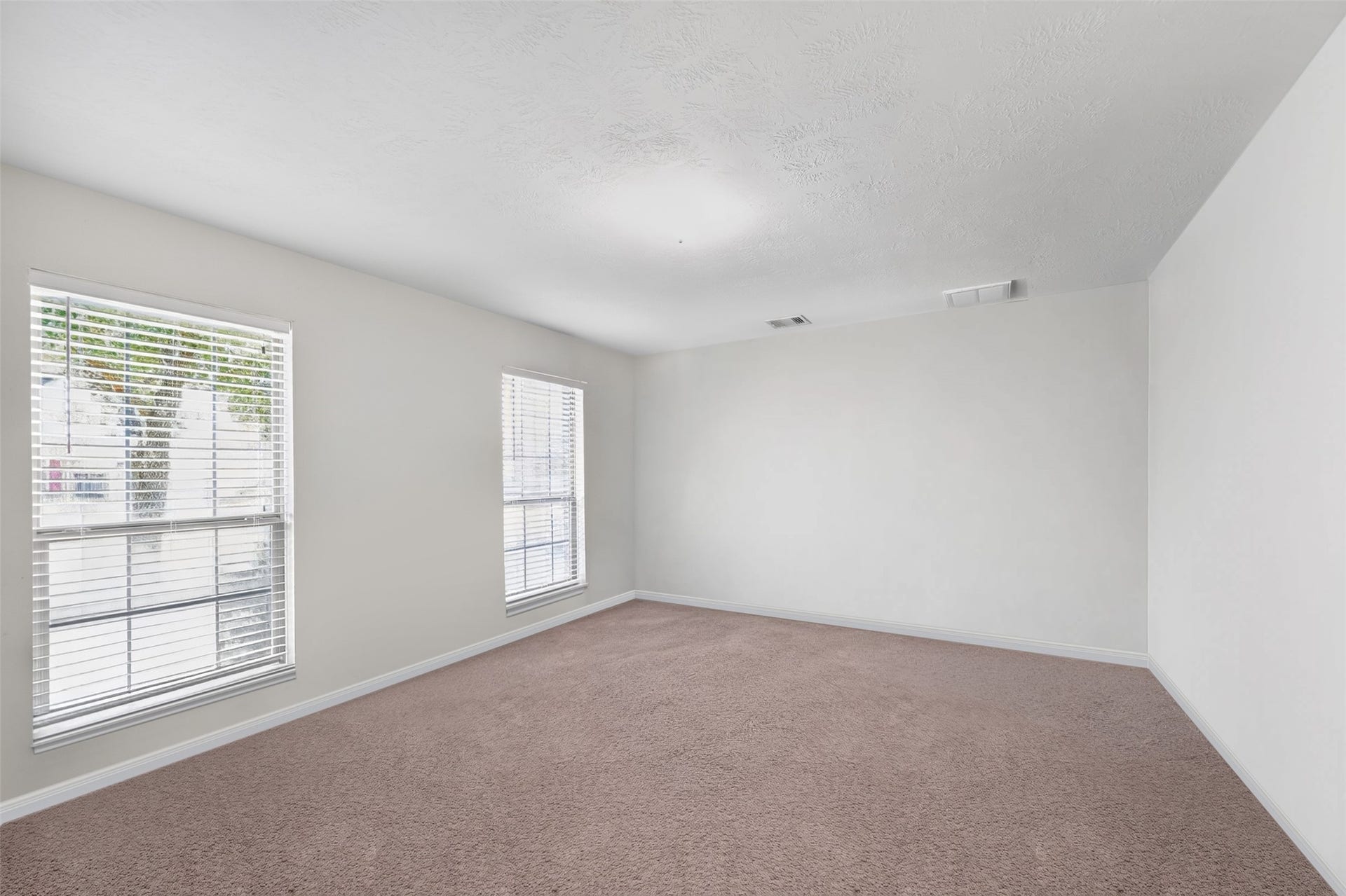 Private secondary bedroom with a bright, airy feel and neutral finishes.
