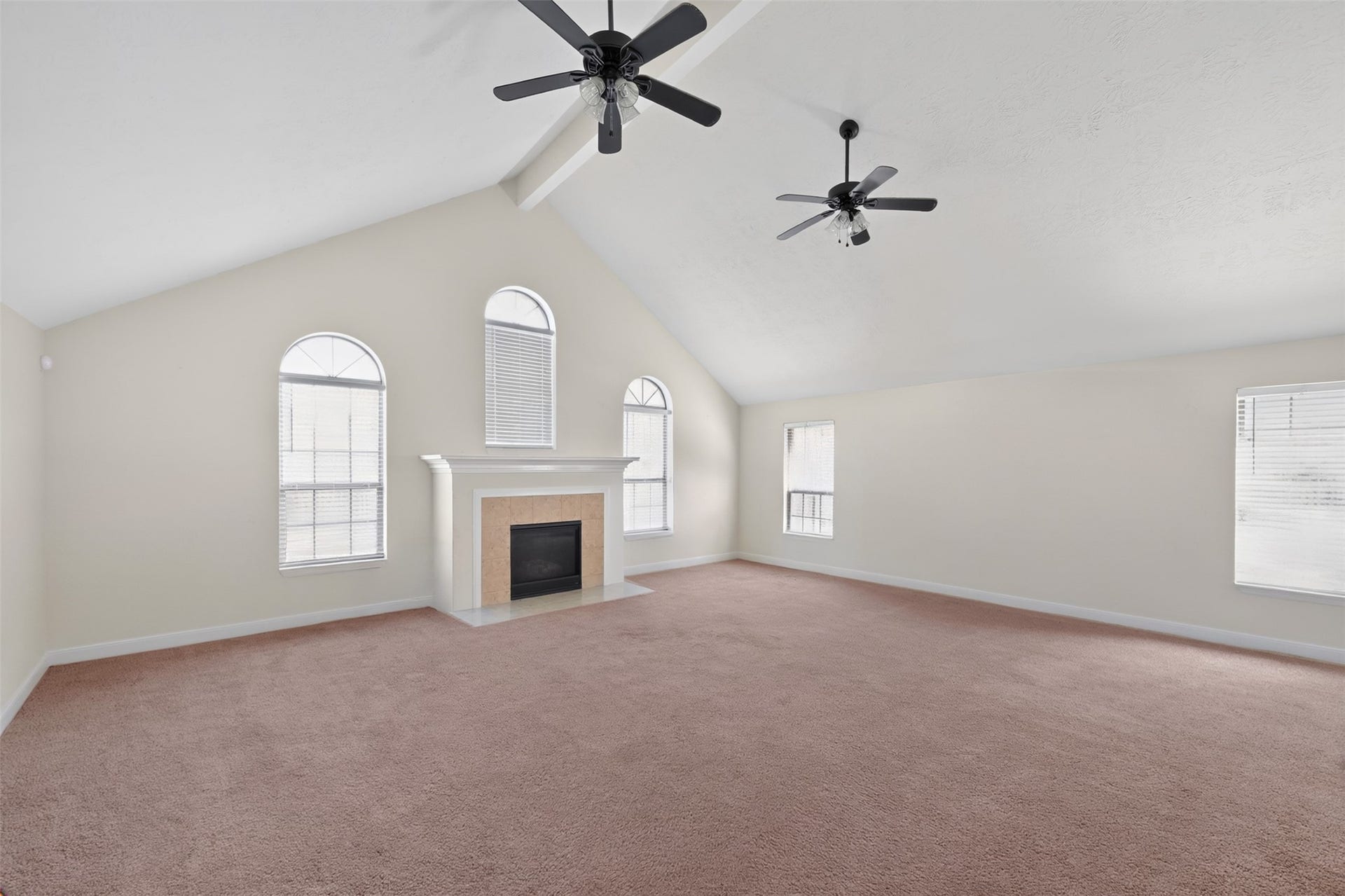 Light-filled family room featuring soaring ceilings, a fireplace, and an open-concept layout.