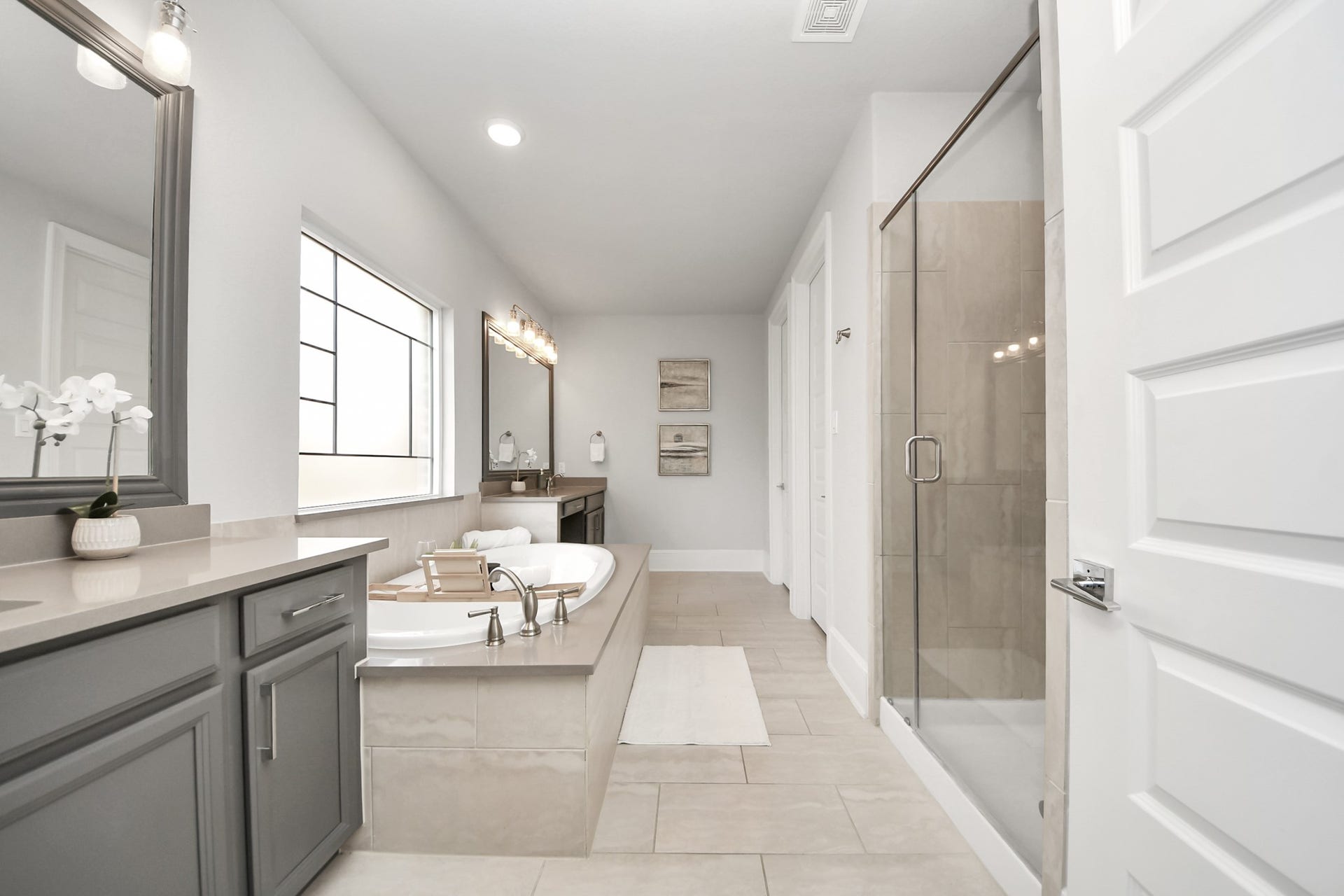 Experience luxury in this elegant primary bathroom featuring a large soaking tub, spacious walk-in shower, double vanity with modern fixtures, and abundant natural light.