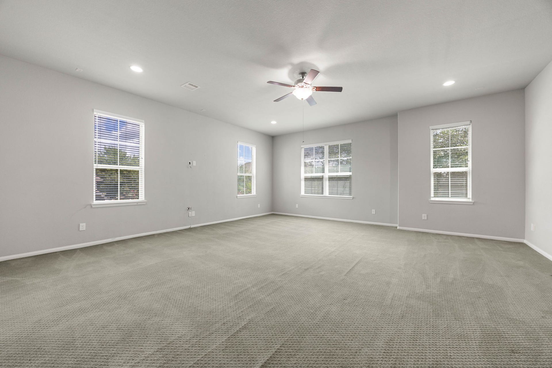 10606 Comeaux Lane, Richmond, TX 77407 A spacious gameroom offers flexible space for recreation or a second living area, framed by windows on two sides for natural light. V
