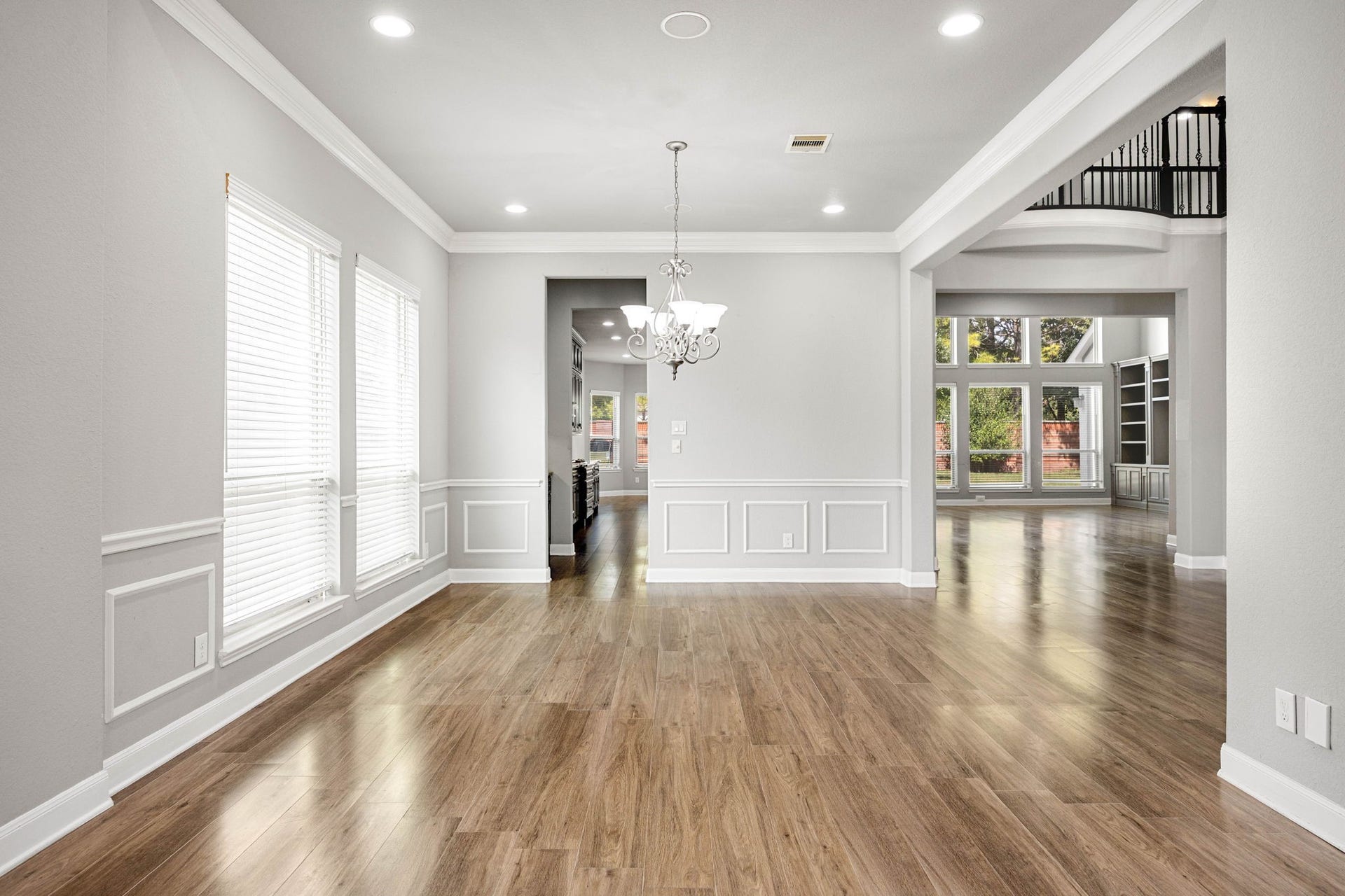 10606 Comeaux Lane, Richmond, TX 77407 Wainscoting and a chandelier lend a polished, formal touch to the dining area, which flows openly toward the kitchen and two-story living space beyond.