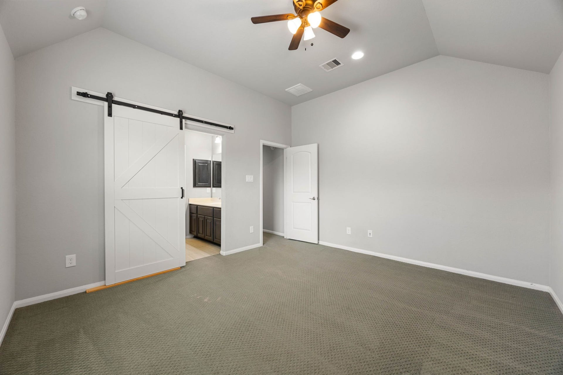 10606 Comeaux Lane, Richmond, TX 77407 A sliding barn door leads from this secondary bedroom directly into a Hollywood bath shared with the adjacent bedroom, adding a stylish, space-savvy touch to this well-appointed guest space.