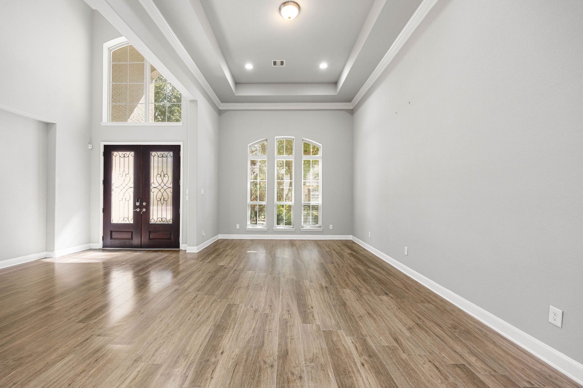 10606 Comeaux Lane, Richmond, TX 77407 A tray ceiling and soaring arched window bring architectural detail to this versatile sitting area just off the foyer, ideal as a formal living space or additional flex room.