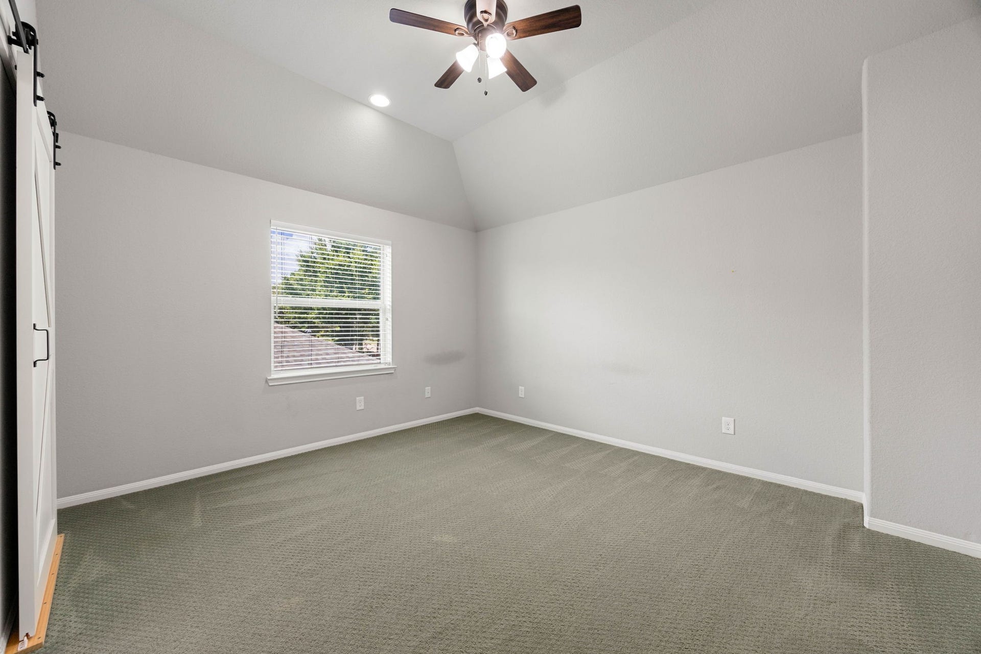 10606 Comeaux Lane, Richmond, TX 77407 Vaulted ceilings and a large window bring extra volume and natural light to this generously sized secondary bedroom.