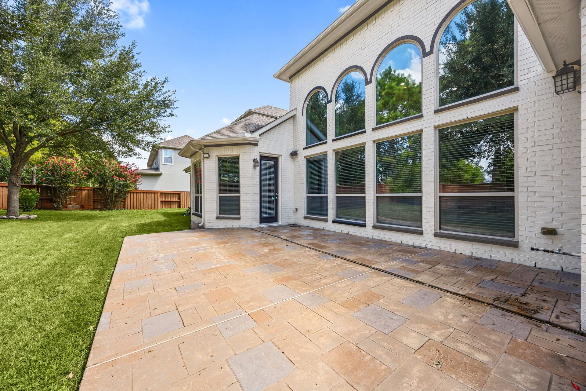 10606 Comeaux Lane, Richmond, TX 77407 The stamped-concrete patio extends along the back of the home, framed by the dramatic two-story arched windows above a versatile space for outdoor dining or relaxing.