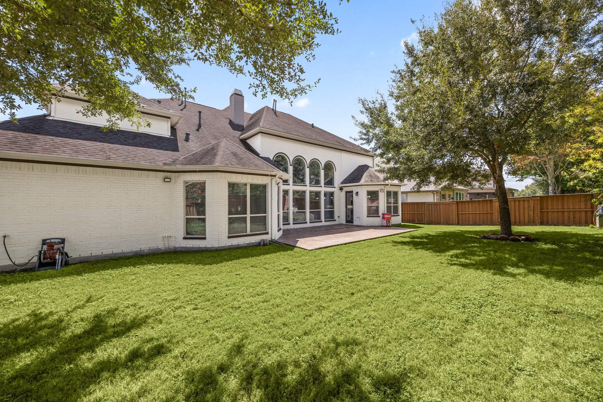 10606 Comeaux Lane, Richmond, TX 77407 A spacious backyard offers plenty of room to enjoy, bordered by a brick privacy wall and mature trees that create natural shade throughout the yard.