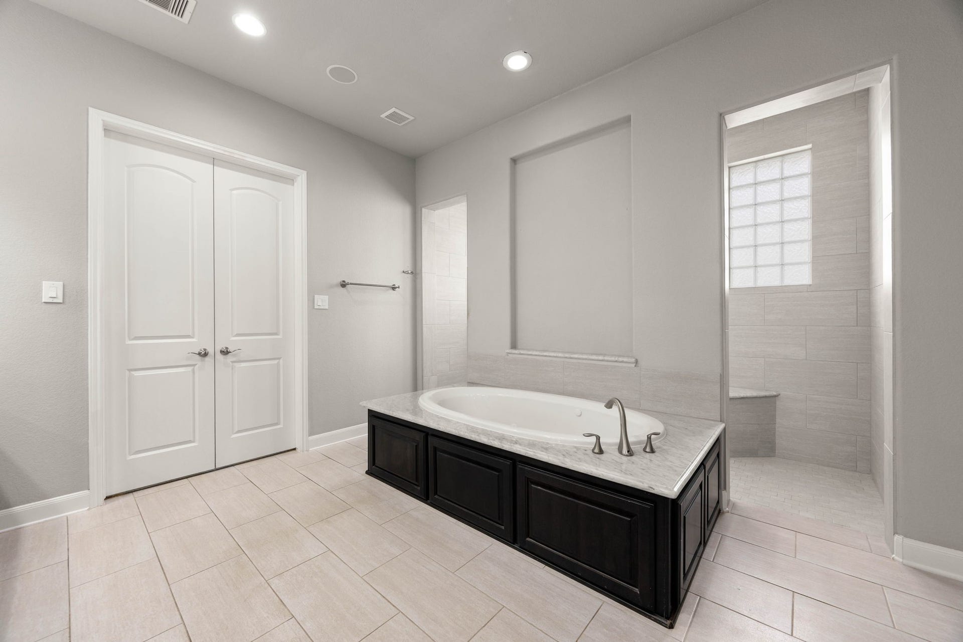 10606 Comeaux Lane, Richmond, TX 77407 A jetted soaking tub takes center stage in this ensuite, framed by marble surround tile and positioned beside a separate walk-in shower for a true spa-like retreat.