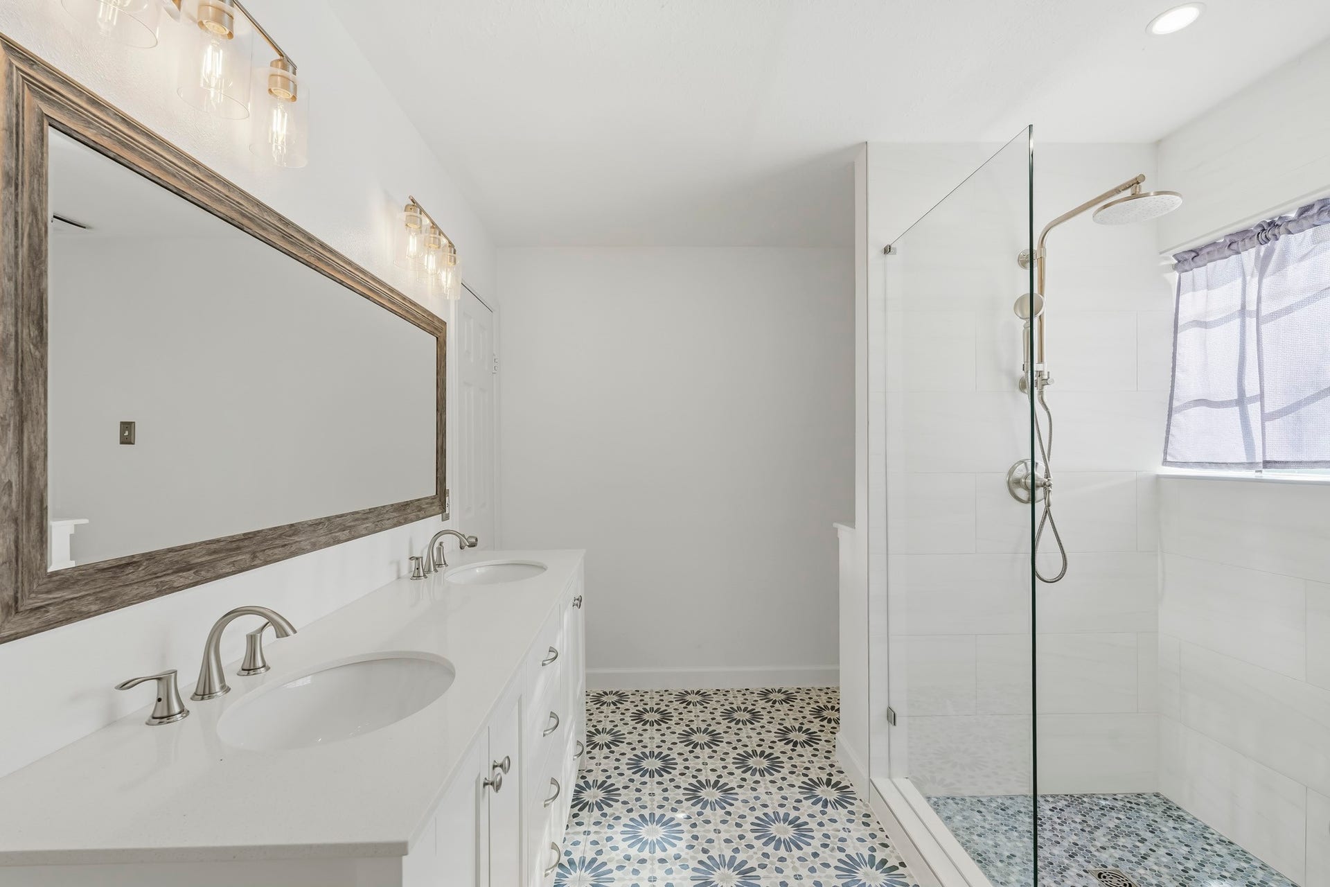 3311 Richmond Ferry Court, Richmond, TX 77406 This beautifully updated primary bathroom features a spacious dual-sink vanity with abundant storage and an oversized framed mirror.