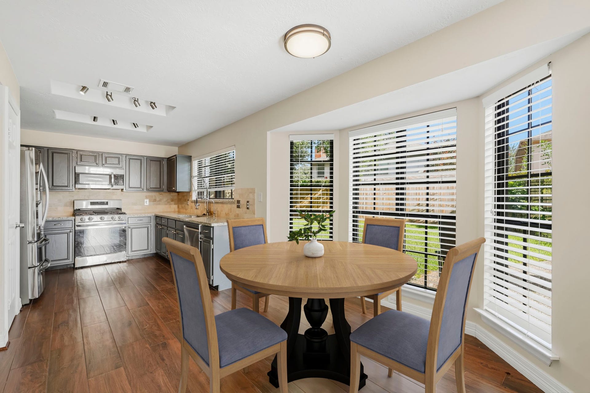 3311 Richmond Ferry Court, Richmond, TX 77406 Virtually Staged: This bright breakfast area flows seamlessly into the kitchen and features warm wood-look flooring with a large bay of windows that fills the space with natural light and offers views of the backyard.