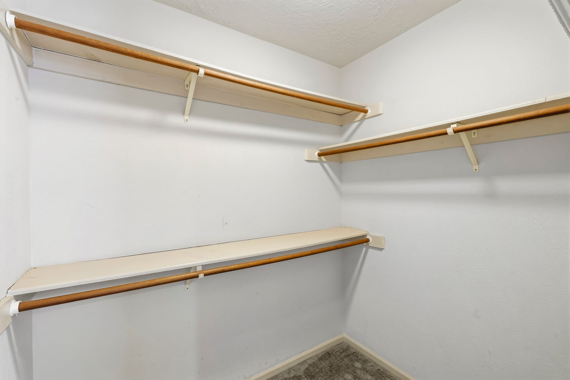 3311 Richmond Ferry Court, Richmond, TX 77406 One of two master closets. This spacious walk-in closet offers abundant storage with multiple hanging rods and built-in shelving along several walls.