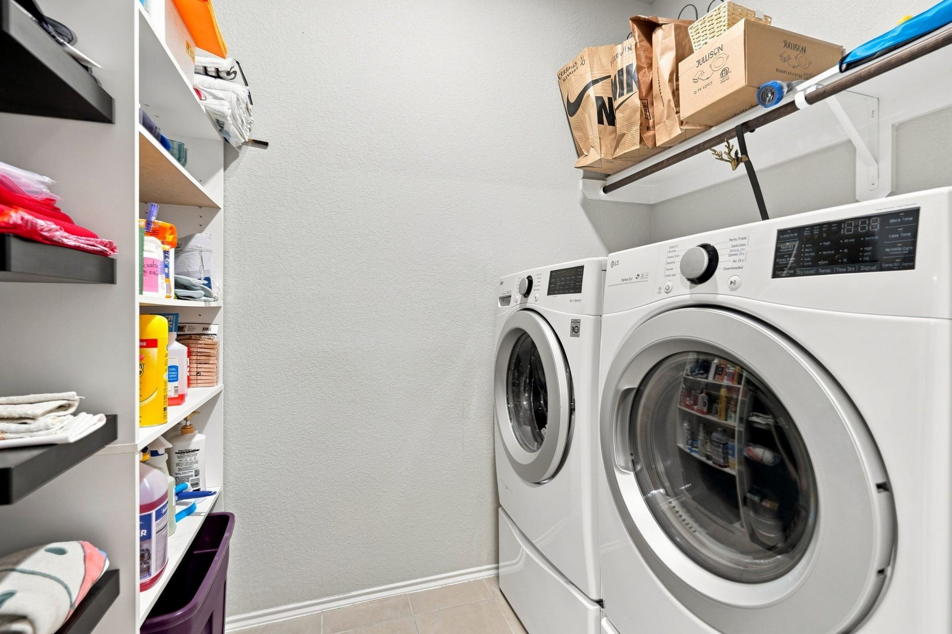 2307 Northern Great White Court, Katy, TX 77449 A well-organized laundry space offering side-by-side washer and dryer hookups flanked by custom storage cubbies and floating shelves.