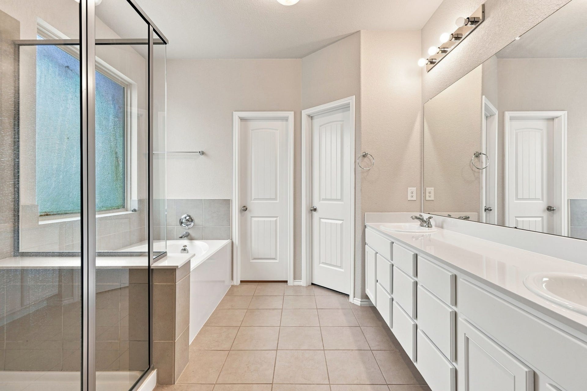 2307 Northern Great White Court, Katy, TX 77449 An alternate angle of the primary bath highlights an expansive dual-sink vanity with broad counter space, generous under-cabinet storage, and vanity lighting.