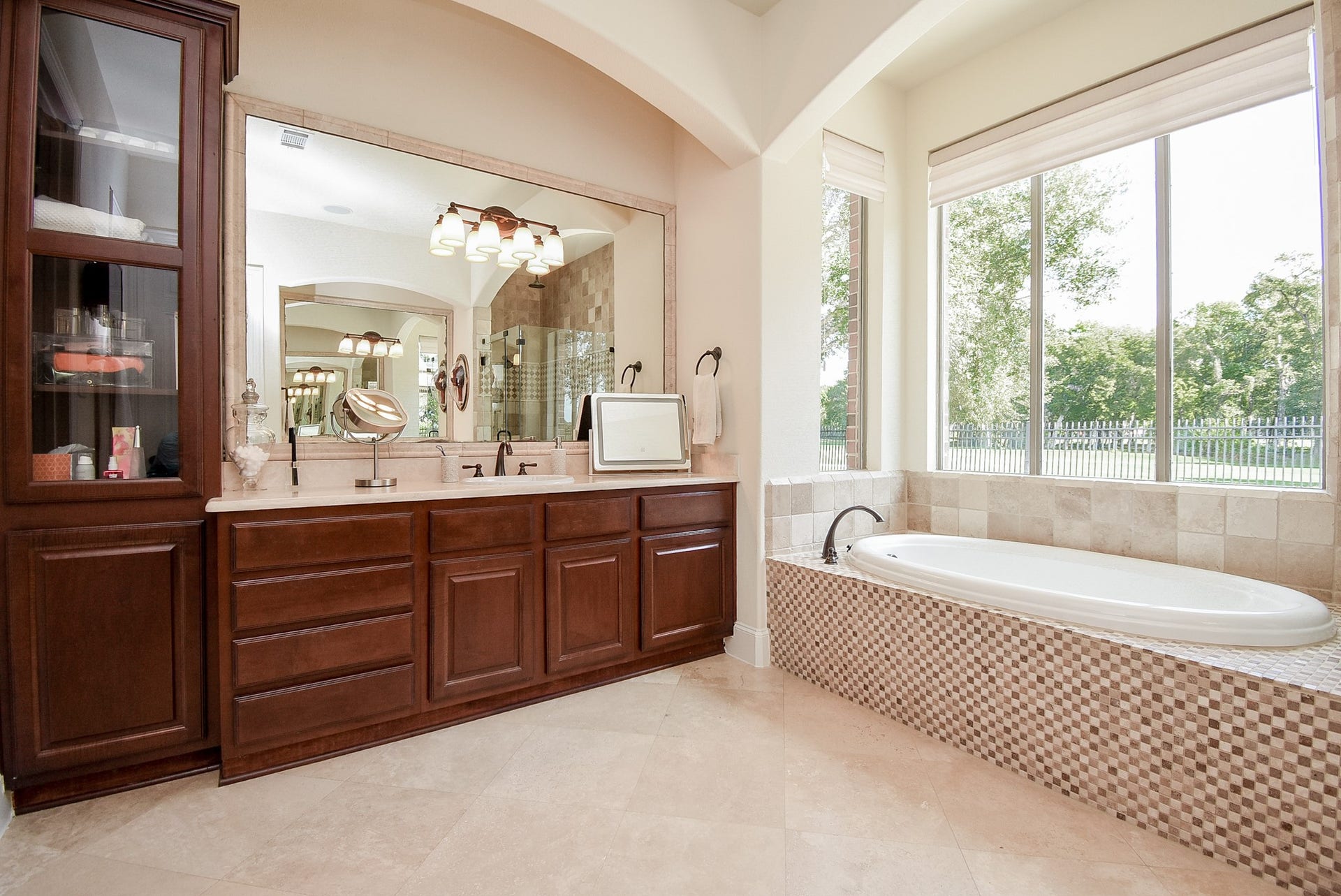 Light and bright. SEcond vanity with tall glass cabinet. Plenty of storage in this picturesque primary bath. A large walk in custom closet completes the suite.